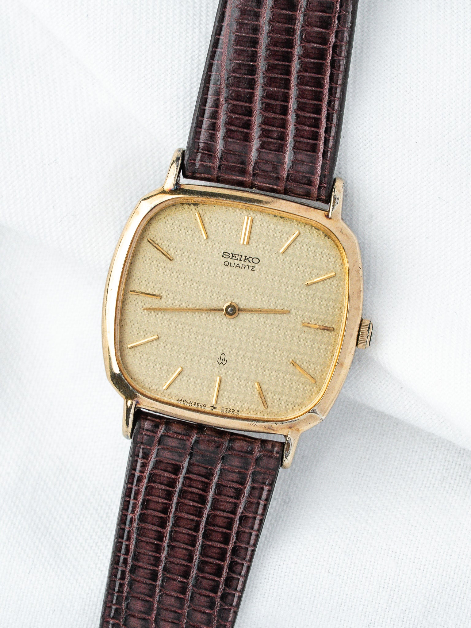 Seiko Quartz vintage watch with gold case, cream dial, and brown lizard strap