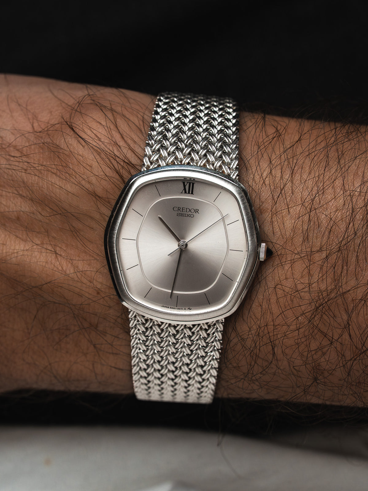 Montre Seiko Credor vintage en acier, boîtier octogonal et bracelet maille milanaise au poignet