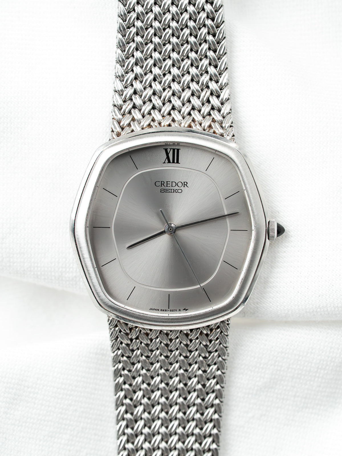 Montre Seiko Credor vintage en acier, cadran argenté et bracelet milanais sur fond blanc