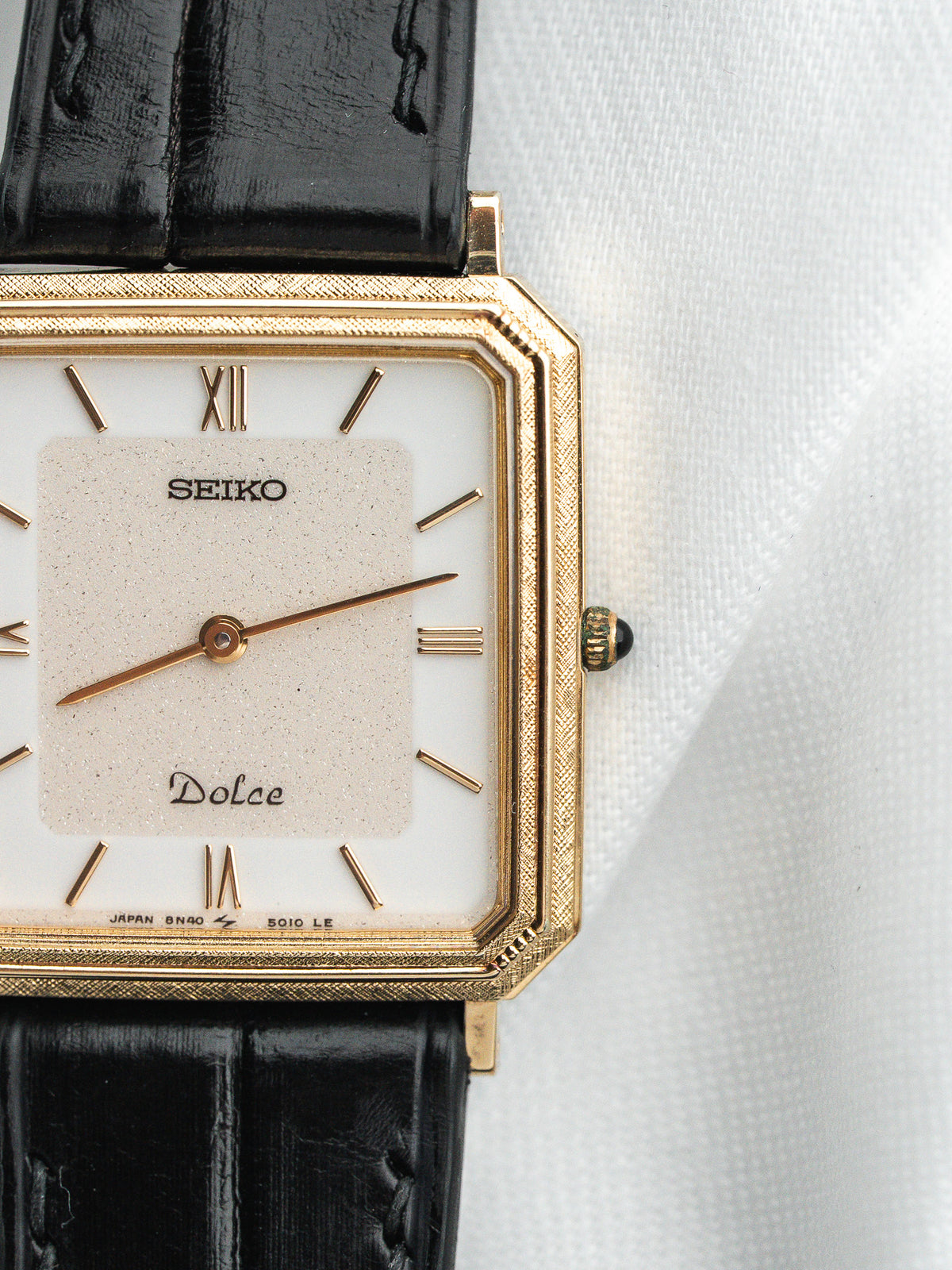 Montre Seiko Dolce vintage, boîtier rectangulaire doré, cadran blanc et bracelet cuir noir