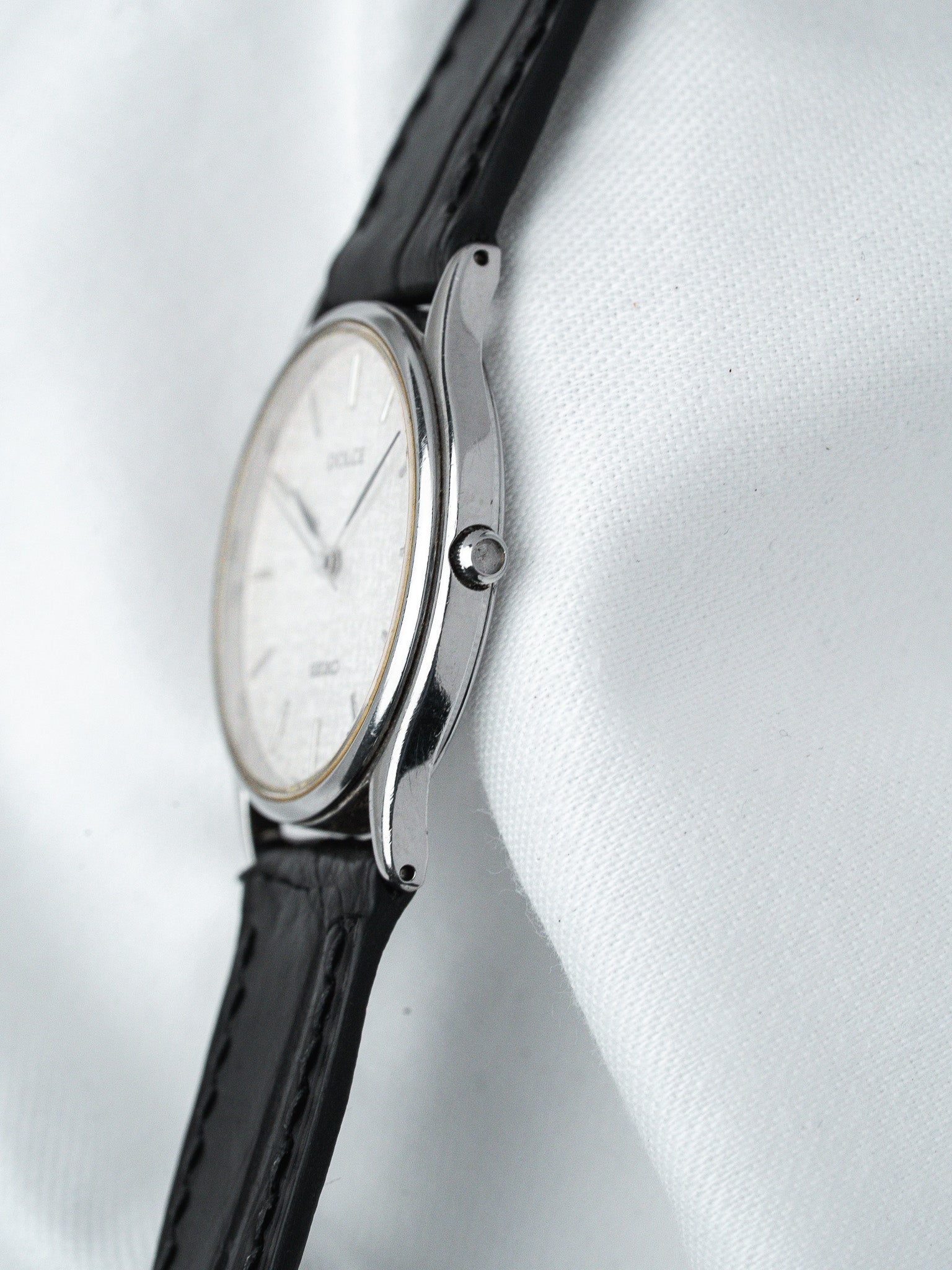 Vintage Seiko wristwatch with silver dial, black leather strap, and stainless steel case