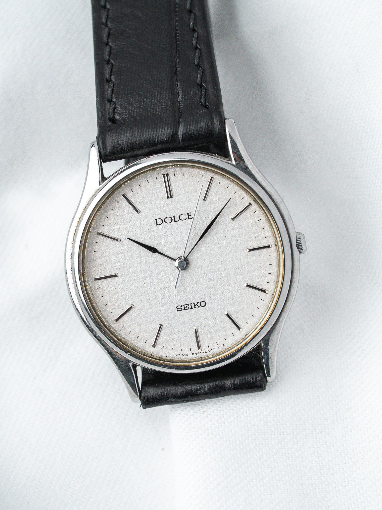 Seiko Dolce vintage watch with silver dial, black leather strap, and steel case