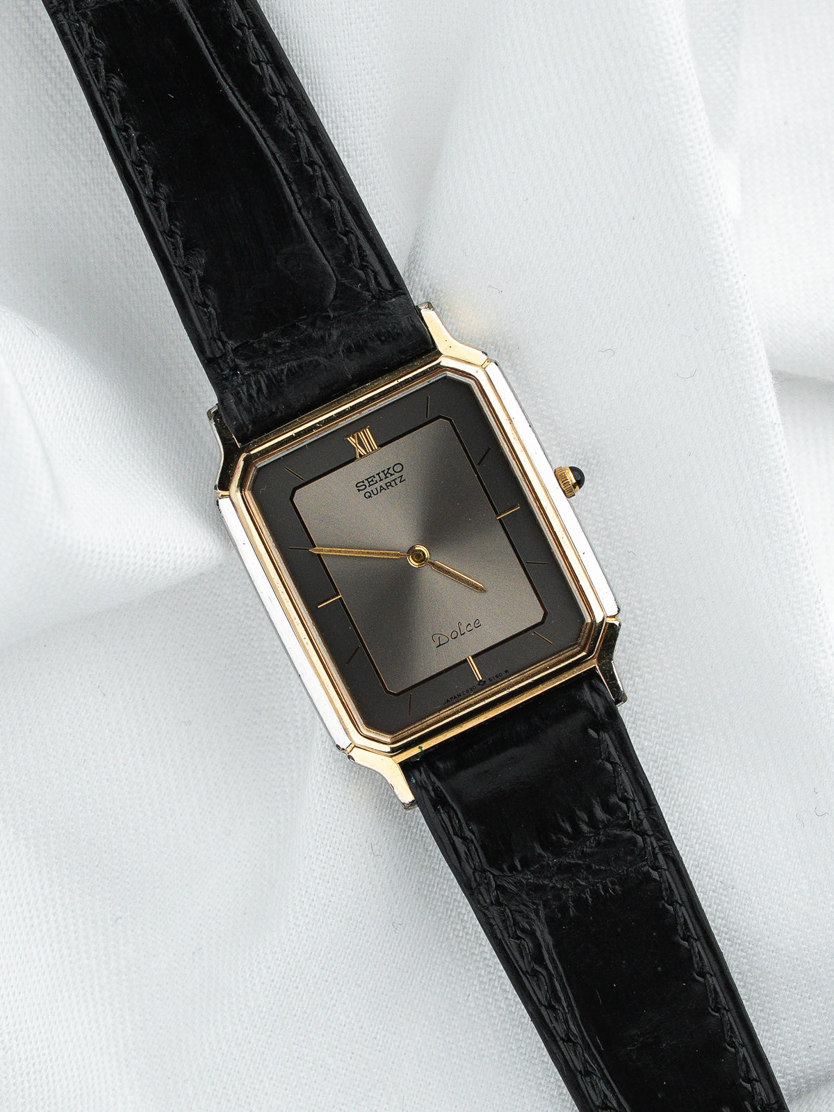 Montre Seiko Dolce vintage, boîtier rectangulaire doré, cadran gris et bracelet cuir noir