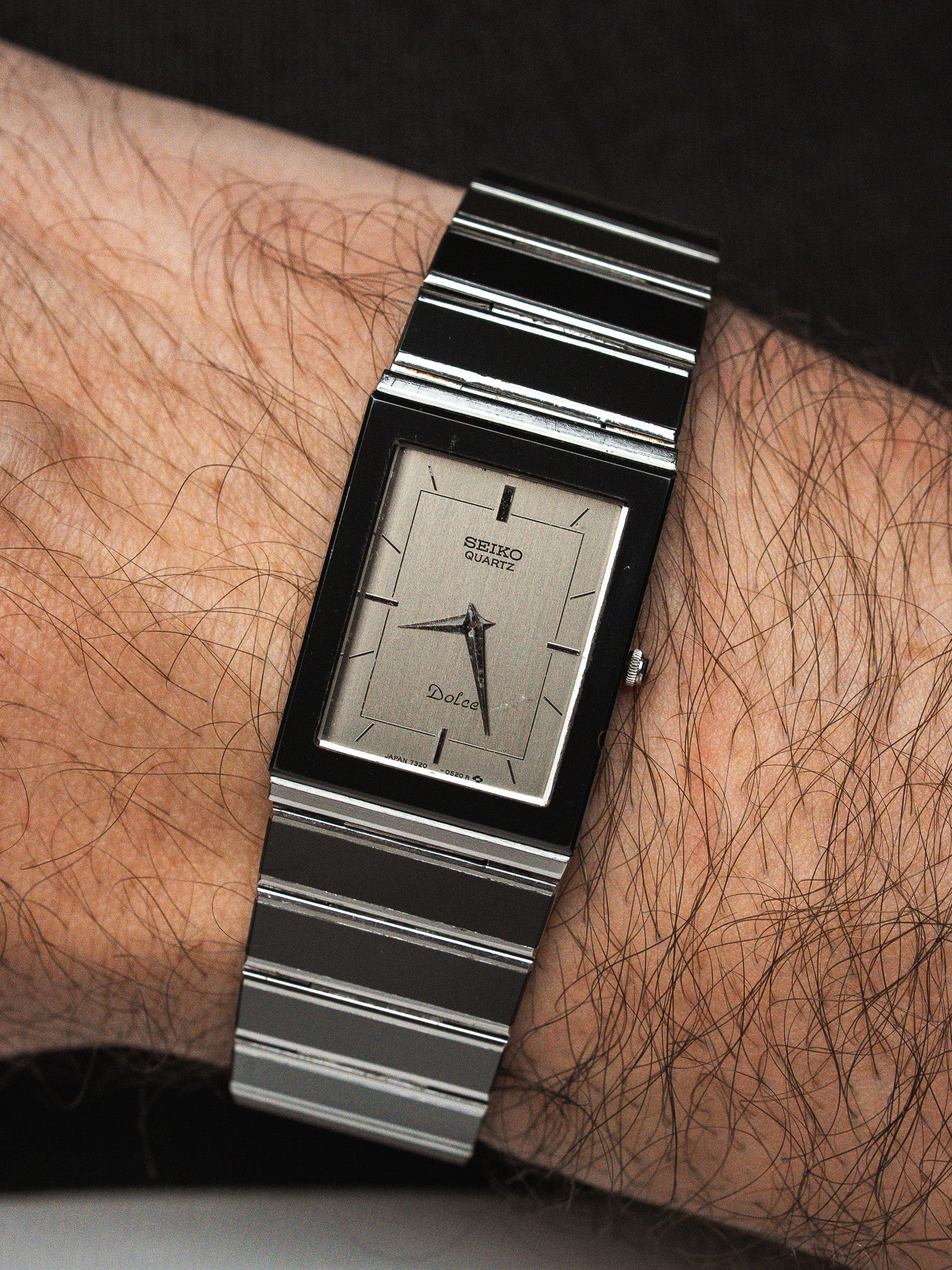 Seiko Dolce vintage quartz watch with rectangular case and striped metal bracelet on wrist