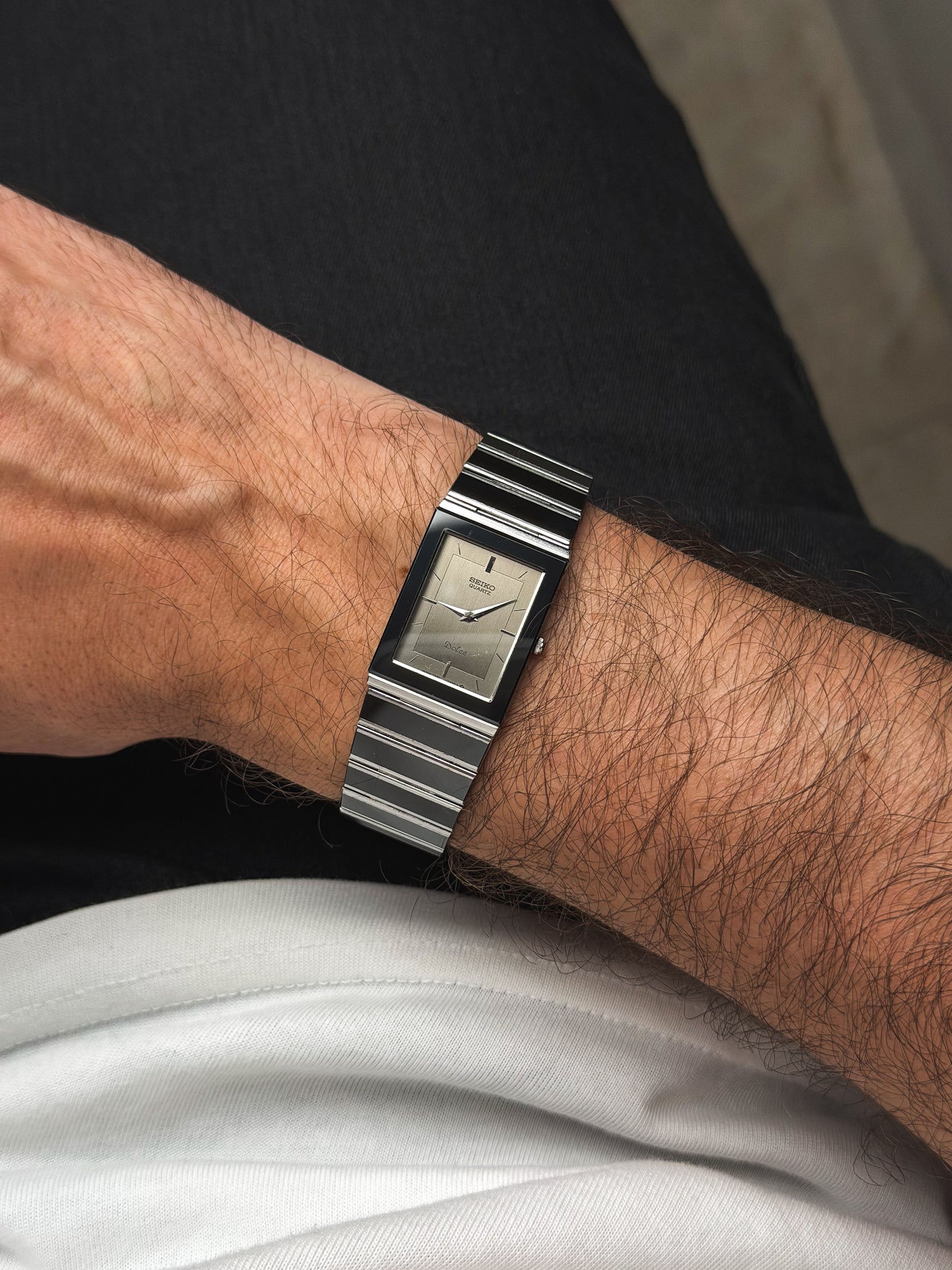 Seiko Dolce vintage watch with rectangular case, silver dial, and striped metal bracelet worn on wrist