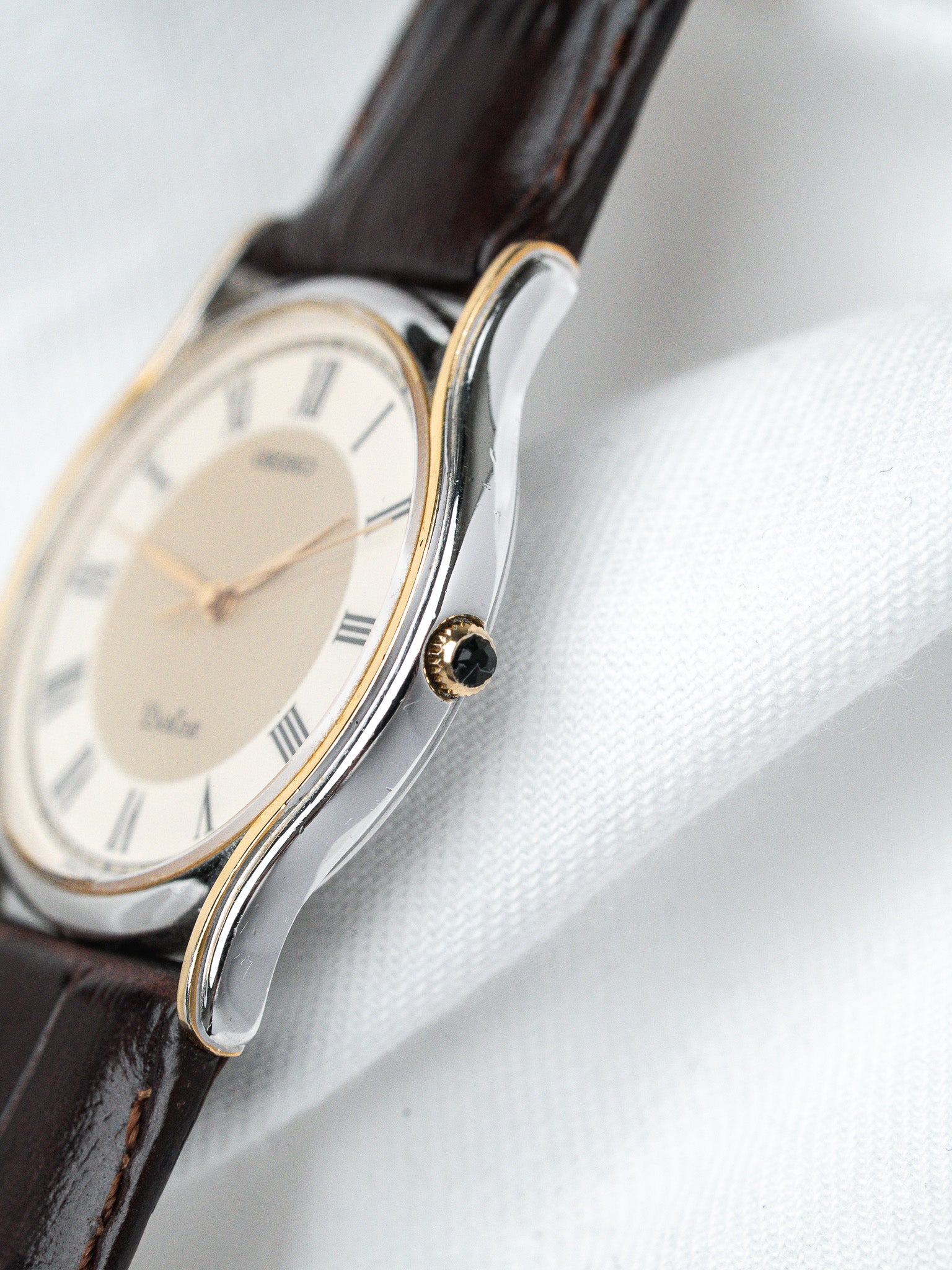 Seiko vintage watch with two-tone case, cream dial, Roman numerals, brown leather strap