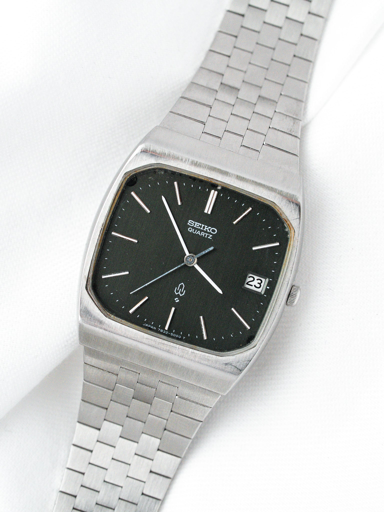 Seiko Quartz vintage watch with black dial, silver case, and metal bracelet on white background