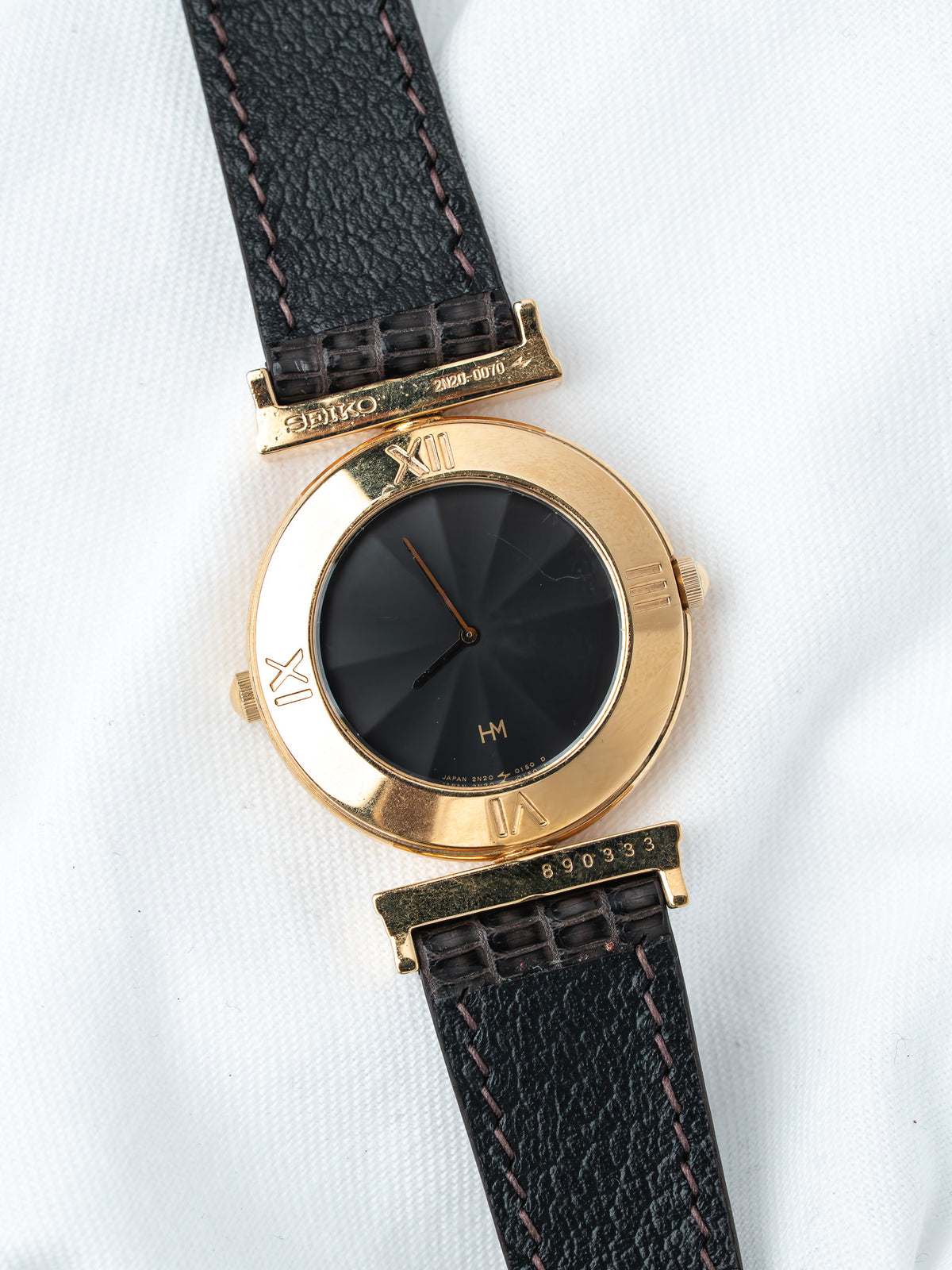 Seiko vintage watch with gold case, black dial, and leather strap