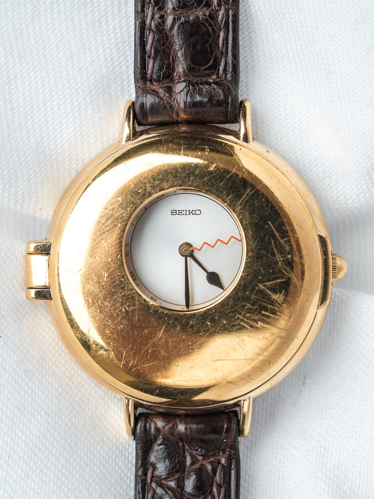 Seiko vintage watch with gold case, white dial, and brown leather strap