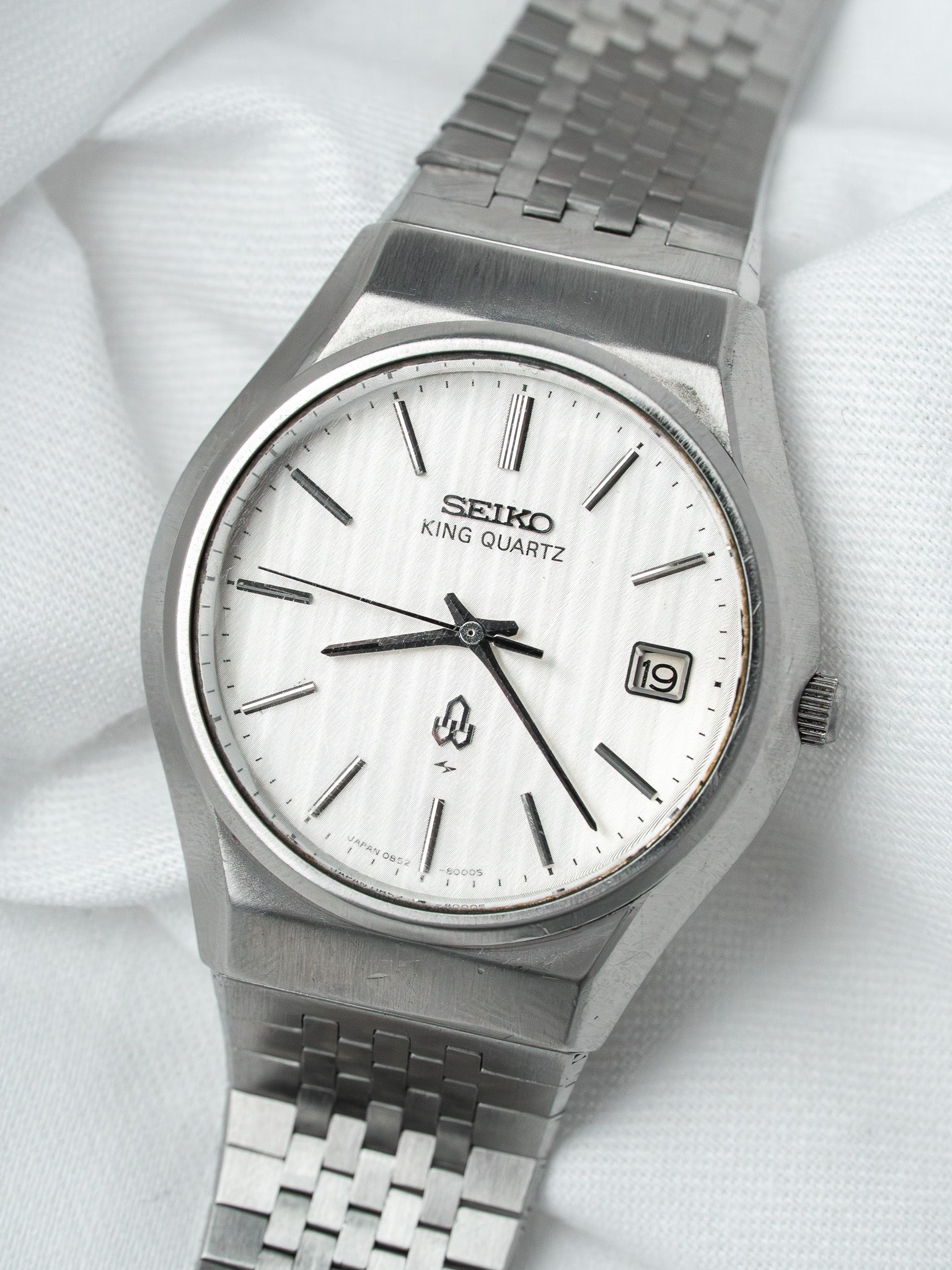 Seiko King Quartz vintage watch with silver dial and steel bracelet on white fabric