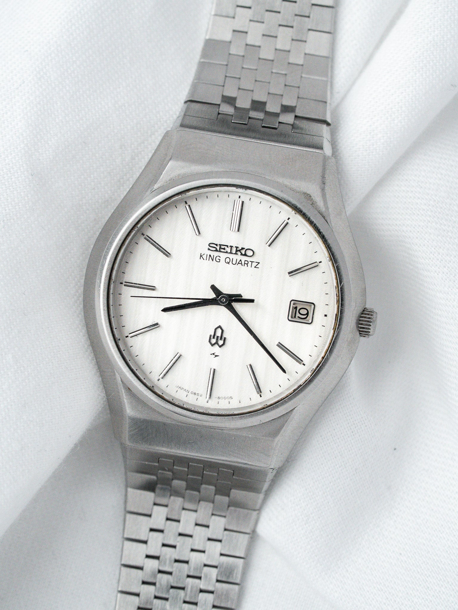 Seiko King Quartz vintage watch with white dial and steel bracelet on fabric