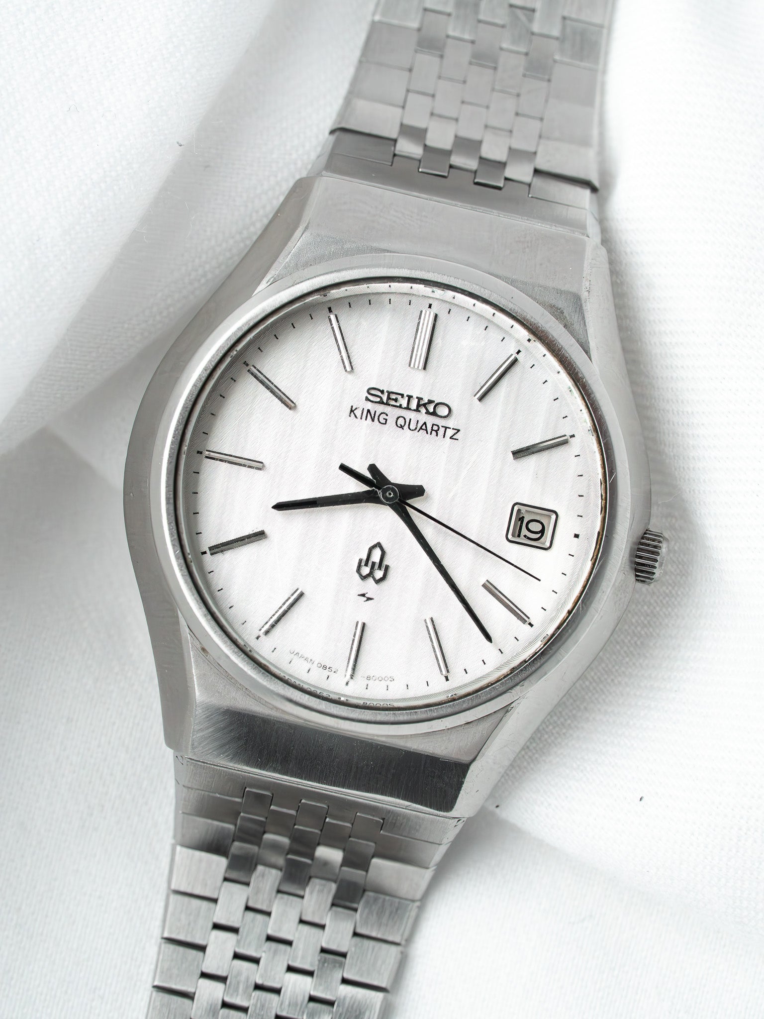 Seiko King Quartz vintage watch with silver dial and metal bracelet on white fabric