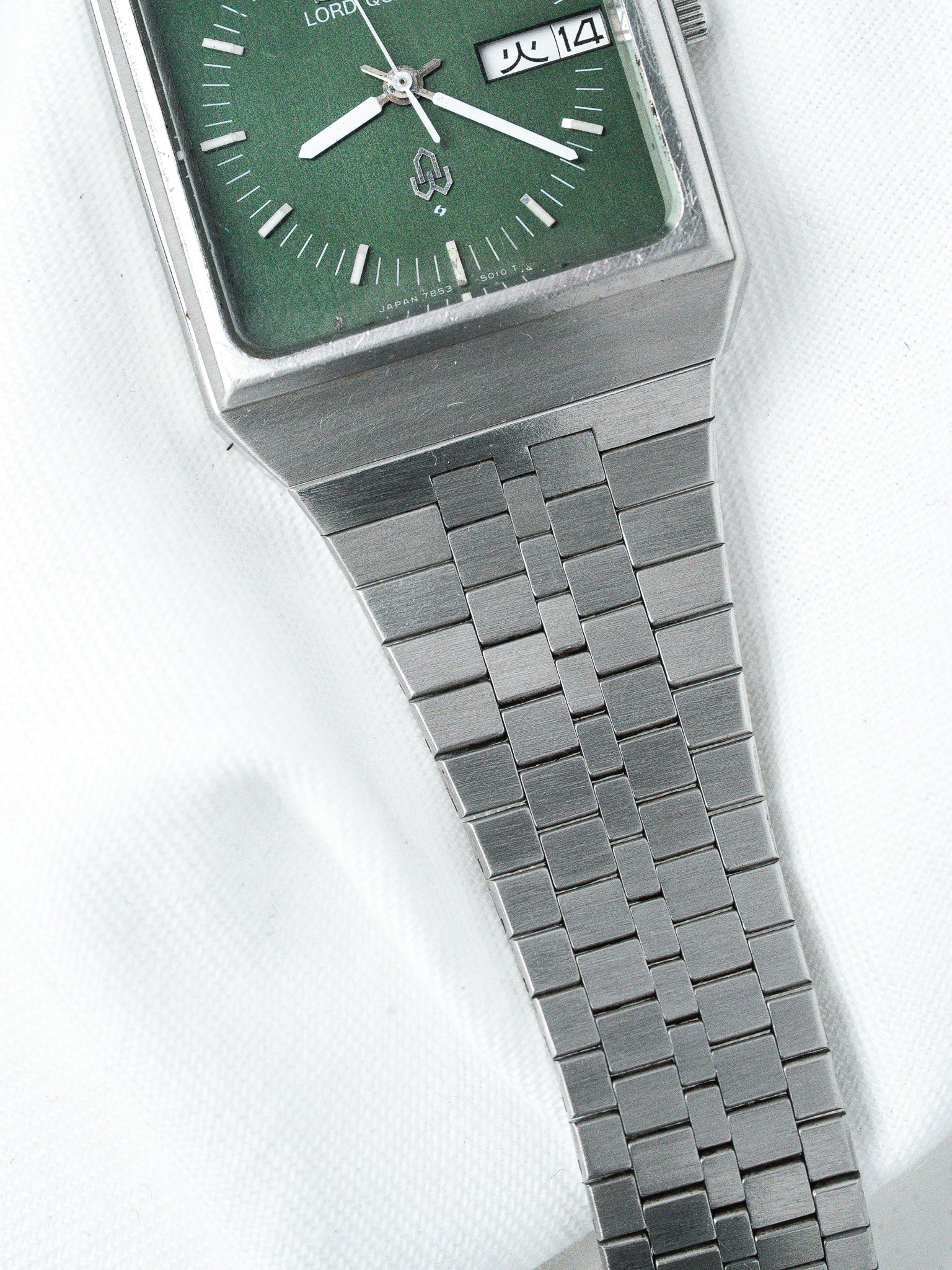 Lord Quartz vintage watch with green dial, silver case, and metal bracelet
