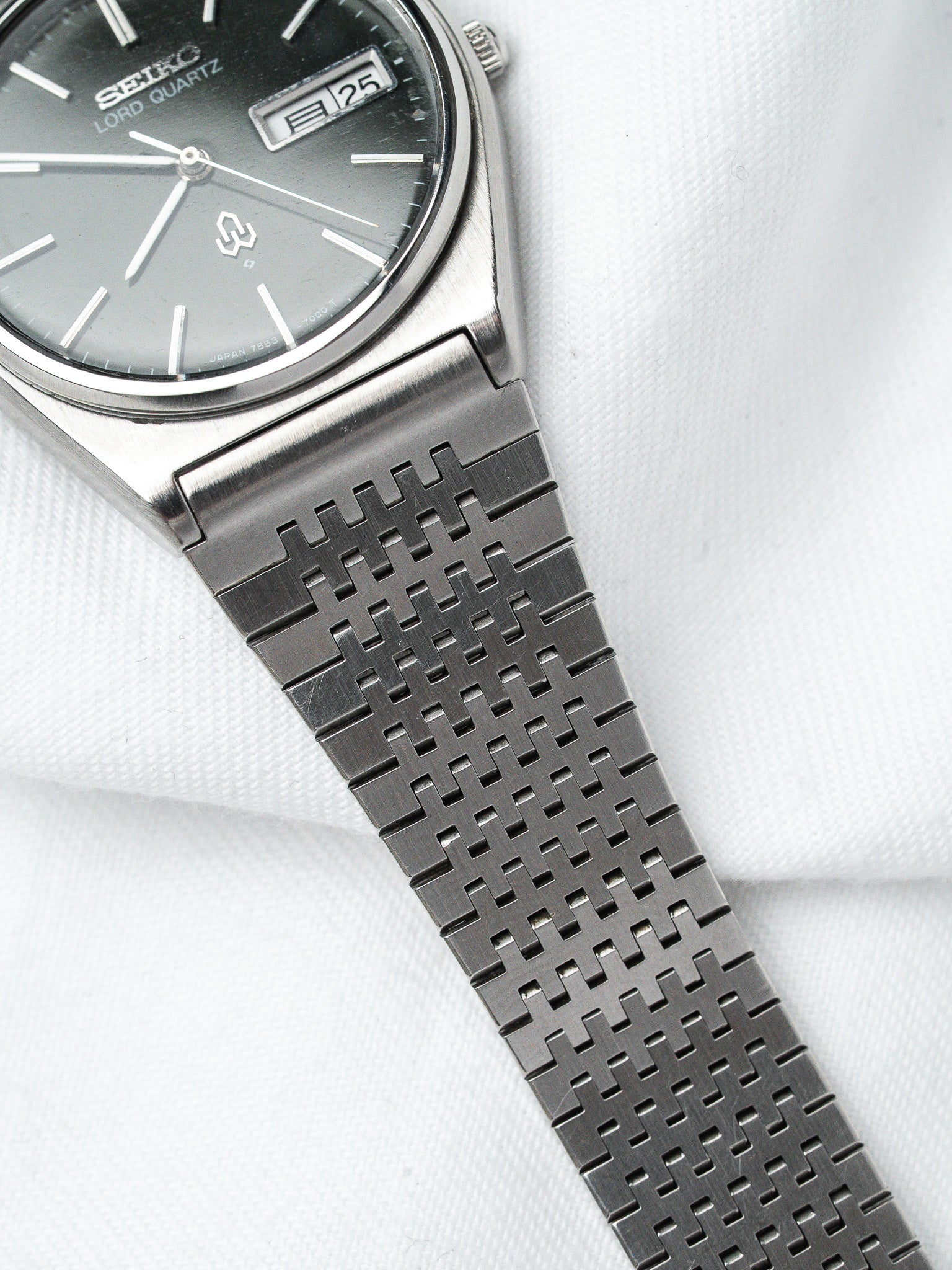 Seiko Lord Quartz vintage watch with gray dial and distinctive mesh bracelet on white fabric