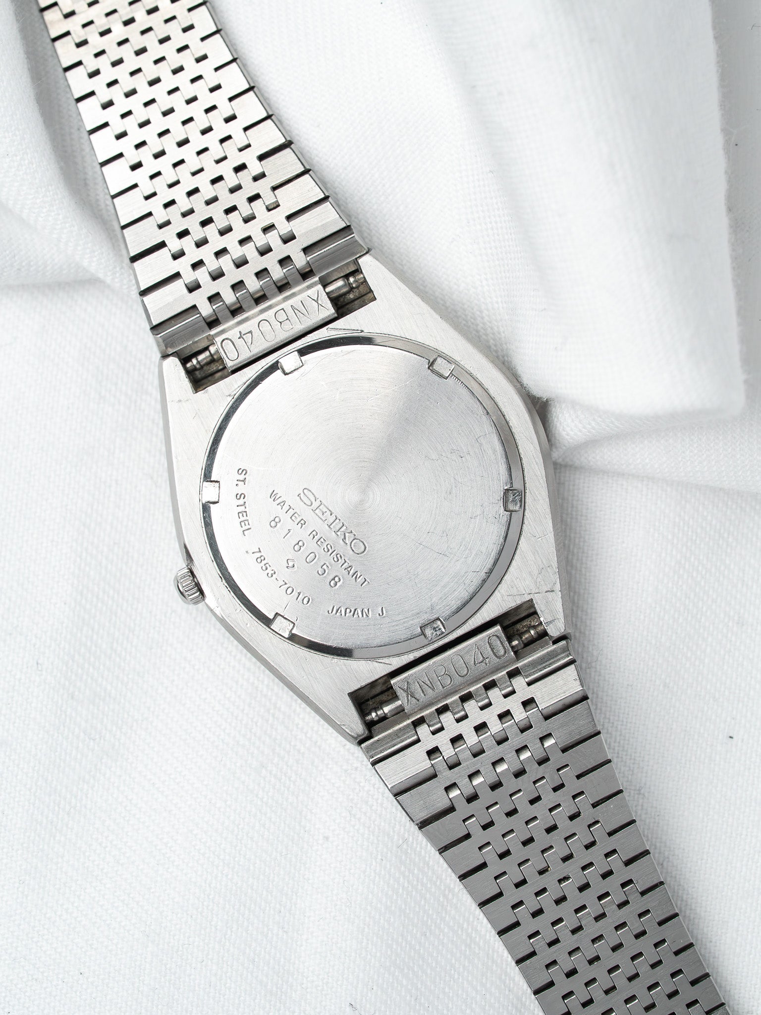 Seiko vintage watch back, stainless steel case, XNB040 bracelet on white fabric