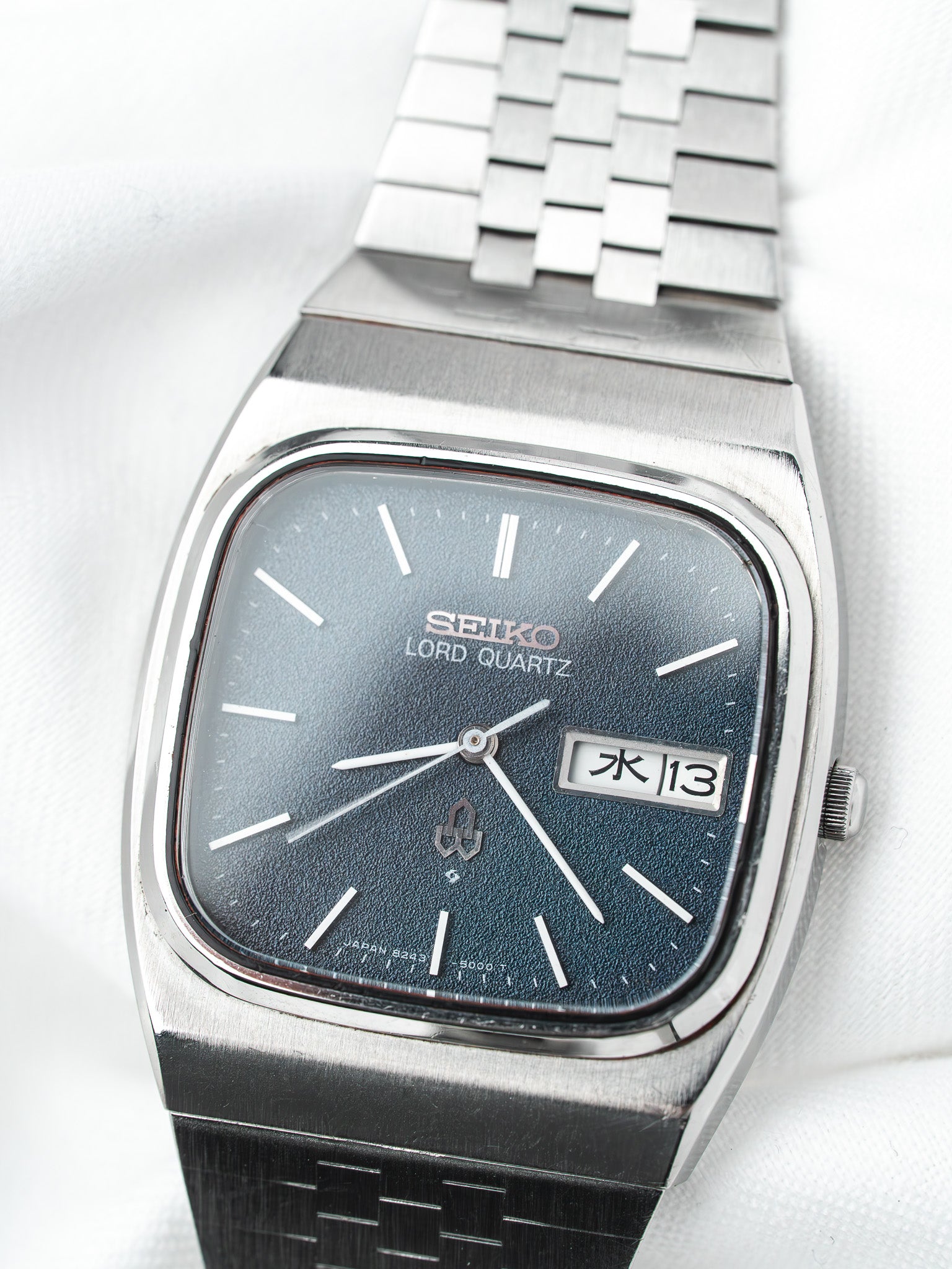 Seiko Lord Quartz vintage watch with blue dial, date window, and steel bracelet on white background