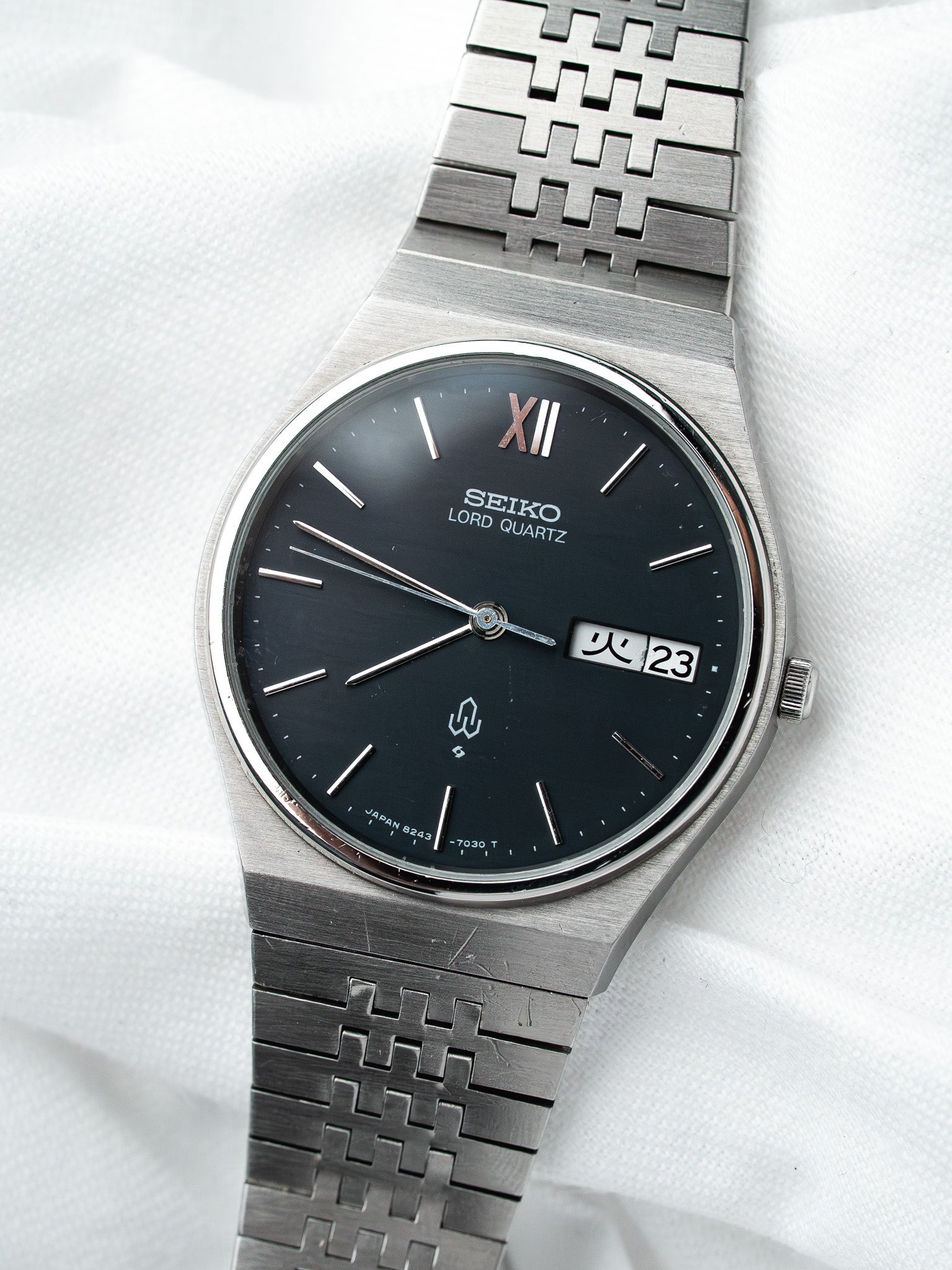 Seiko Lord Quartz vintage watch with black dial, steel bracelet, Roman numeral XII, date window