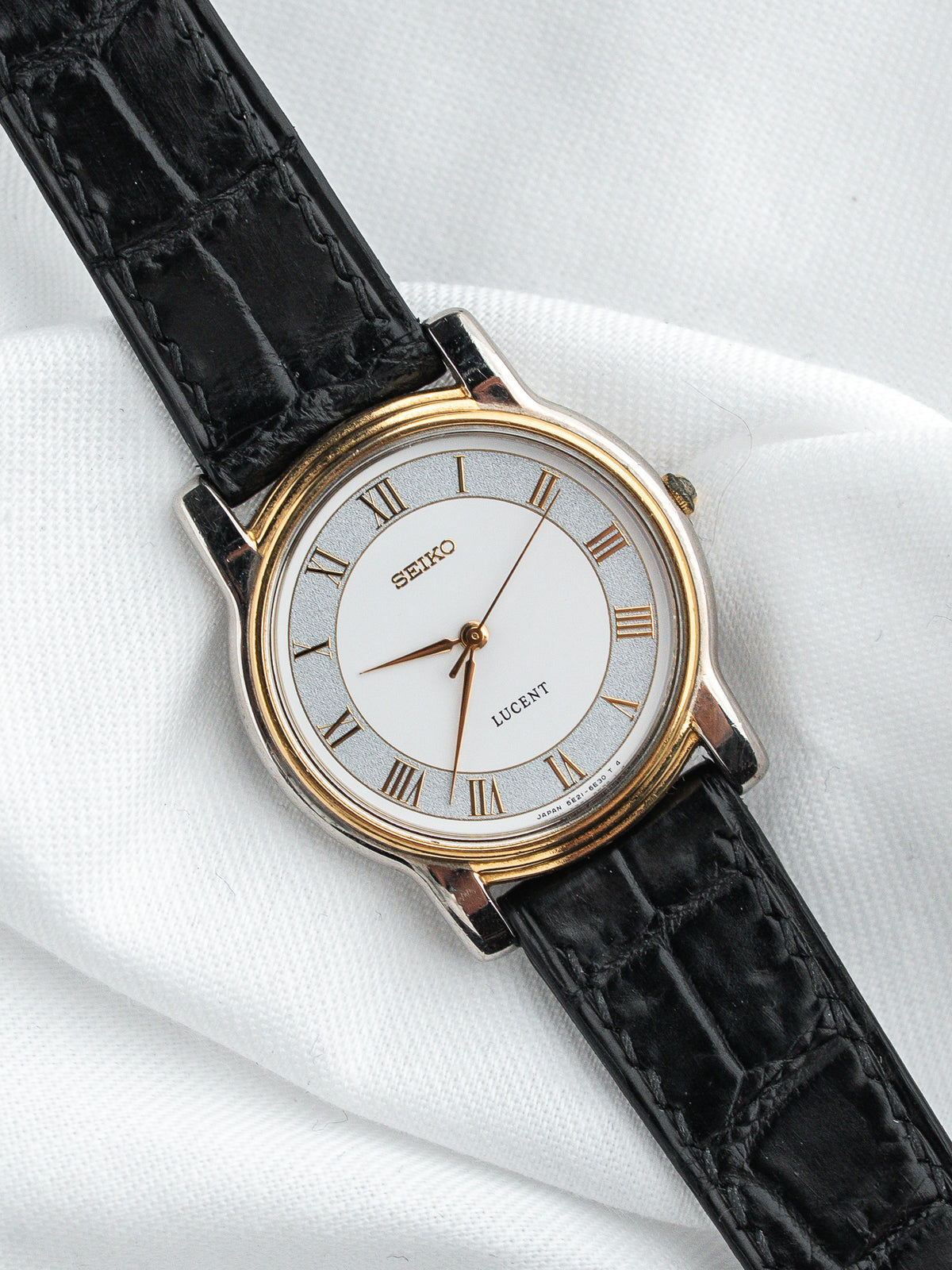 Montre Seiko Lucent vintage au cadran argenté avec bracelet en cuir noir embossé.
