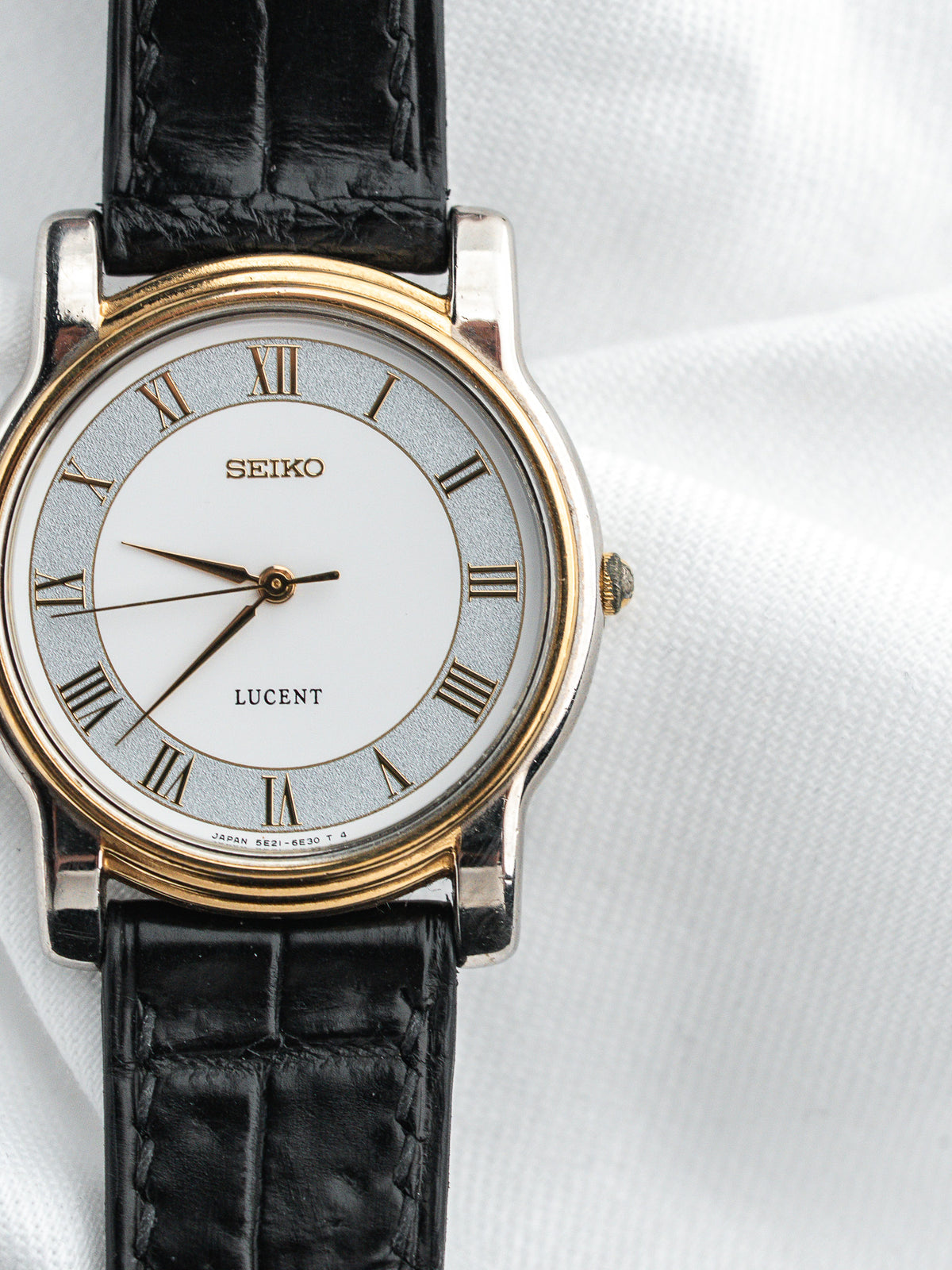Montre Seiko Lucent avec cadran argenté, chiffres romains et bracelet en cuir noir.