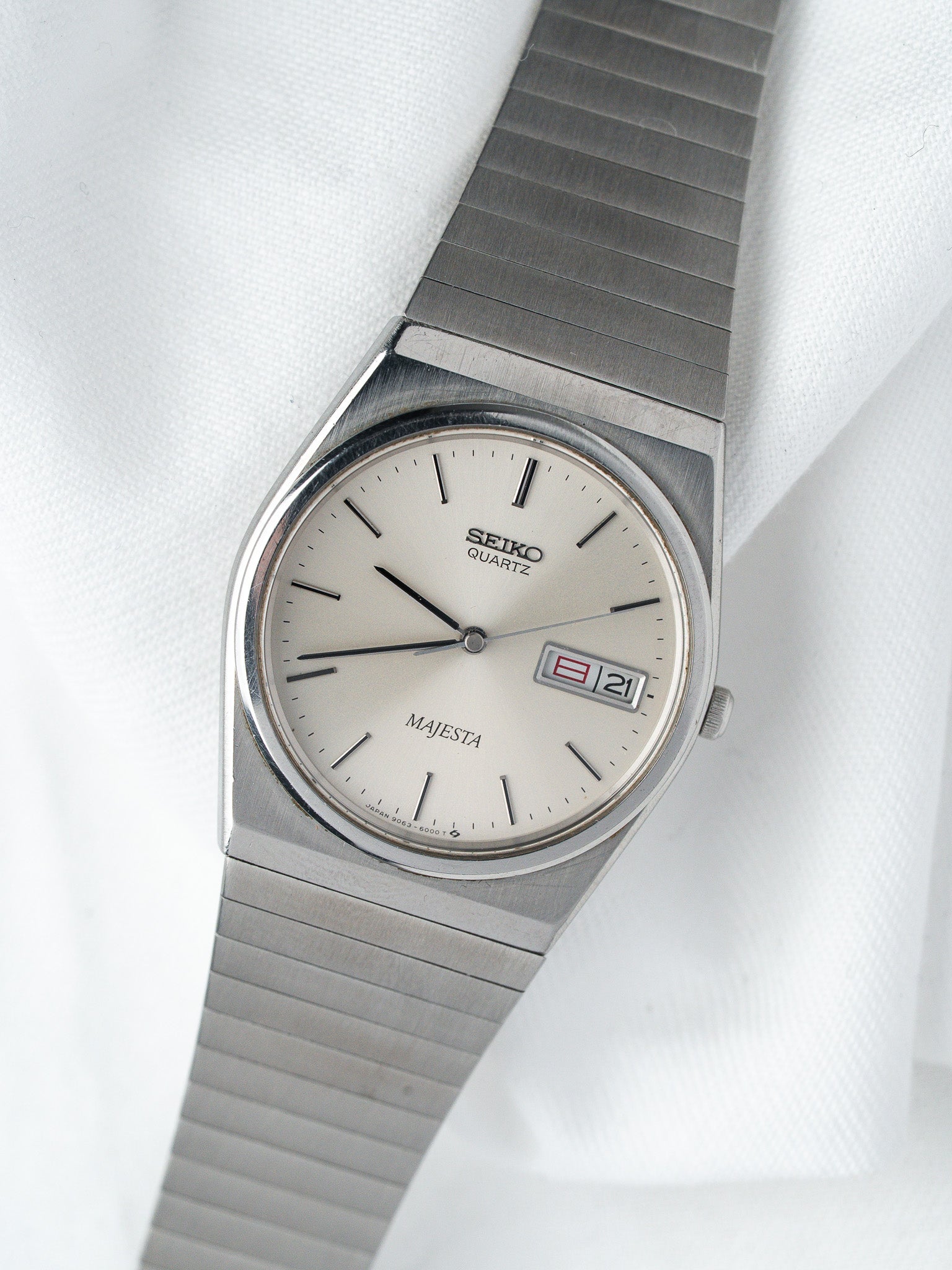 Seiko Majesta vintage quartz watch with silver dial and date, steel bracelet on white fabric