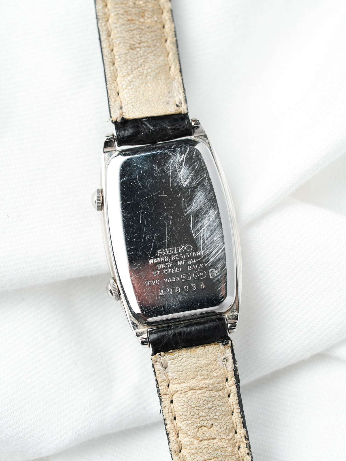Seiko vintage watch with steel case, black leather strap, and engraved back details