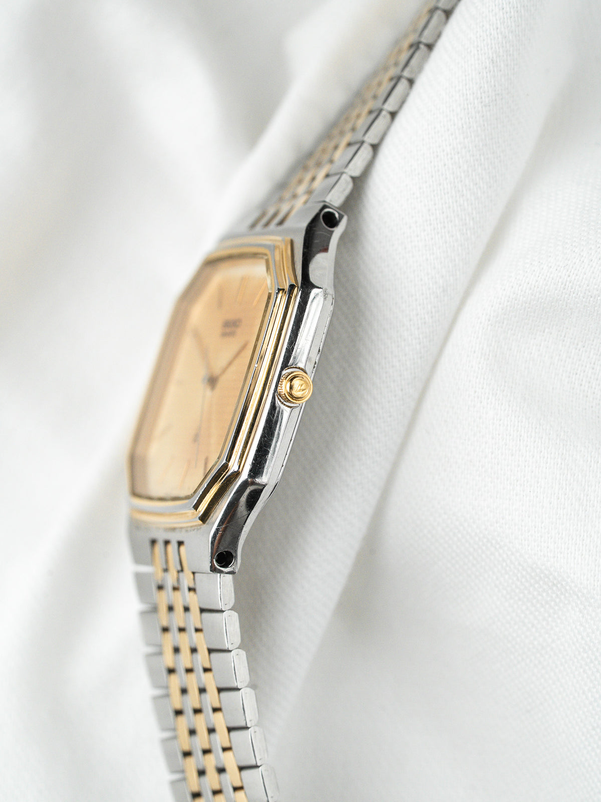 Montre vintage Seiko en acier et or, cadran champagne, sur fond blanc
