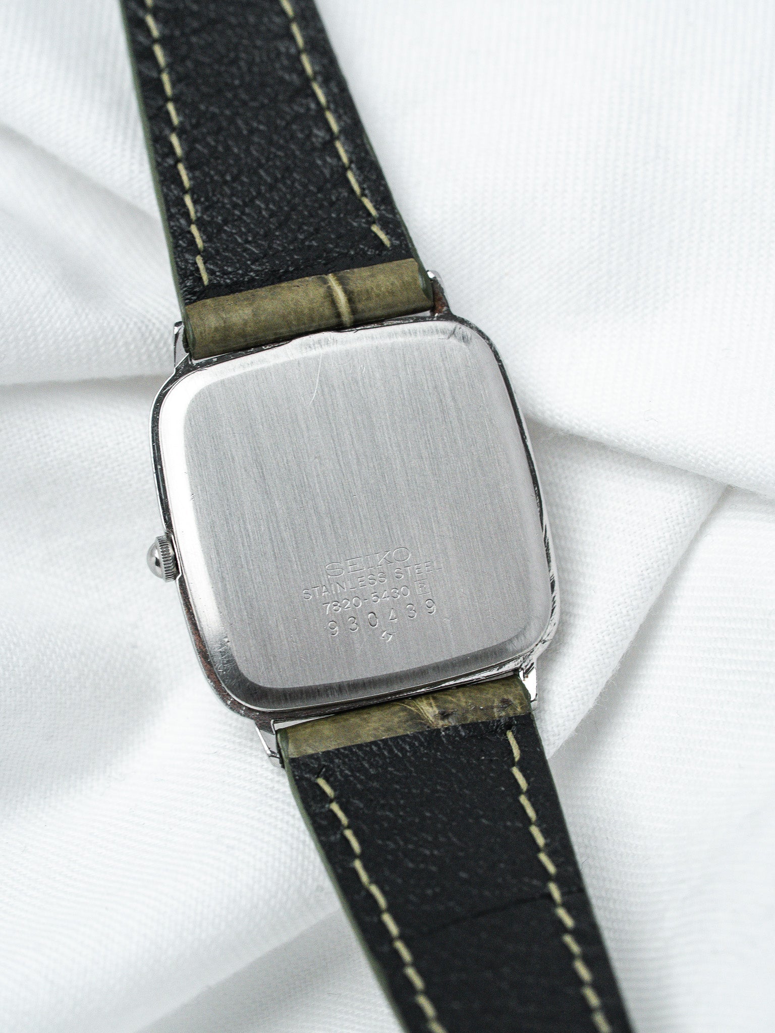 Seiko vintage watch with stainless steel case and black leather strap, back view