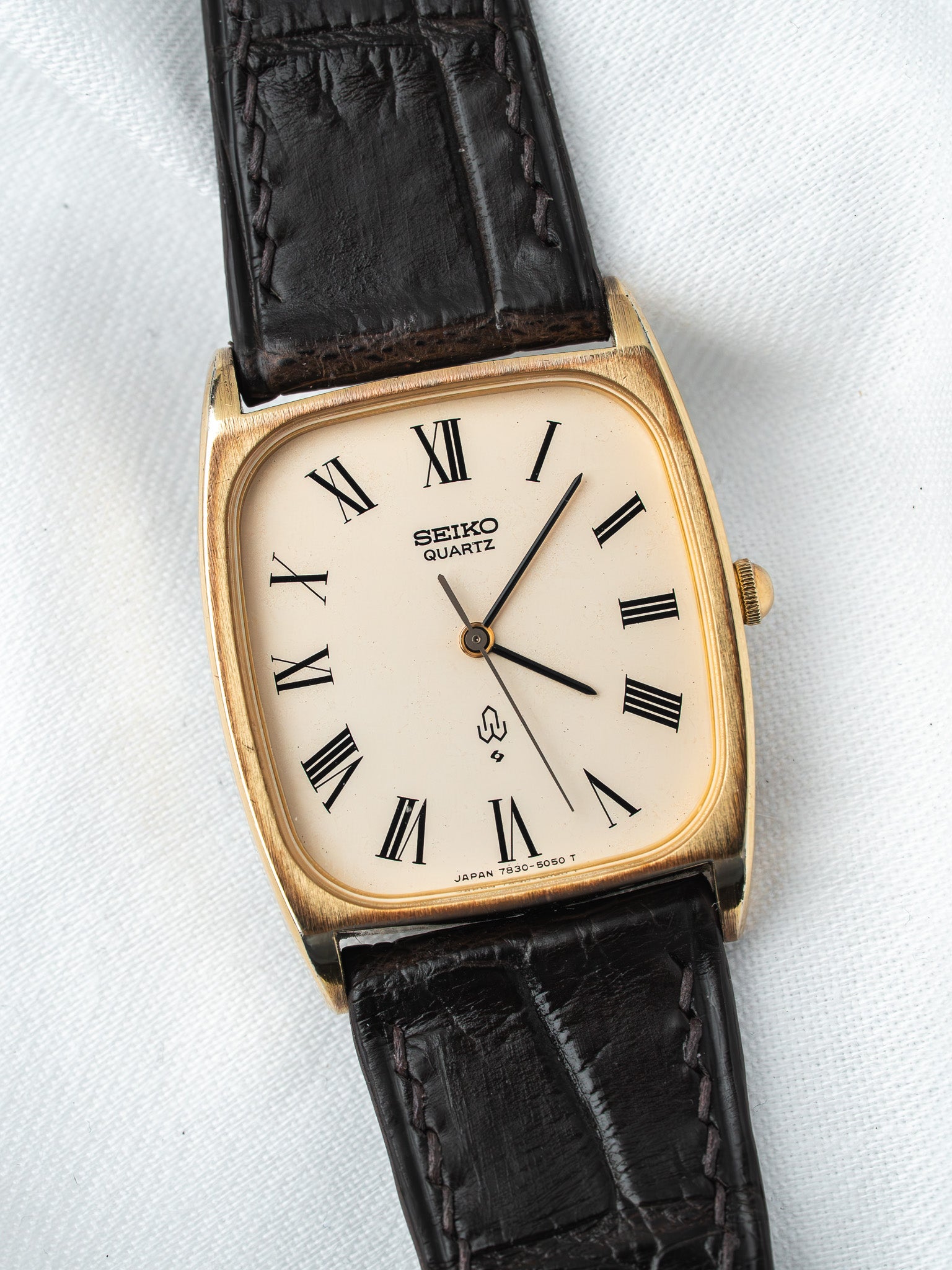 Seiko Quartz vintage watch with gold case, cream dial, Roman numerals, black leather strap