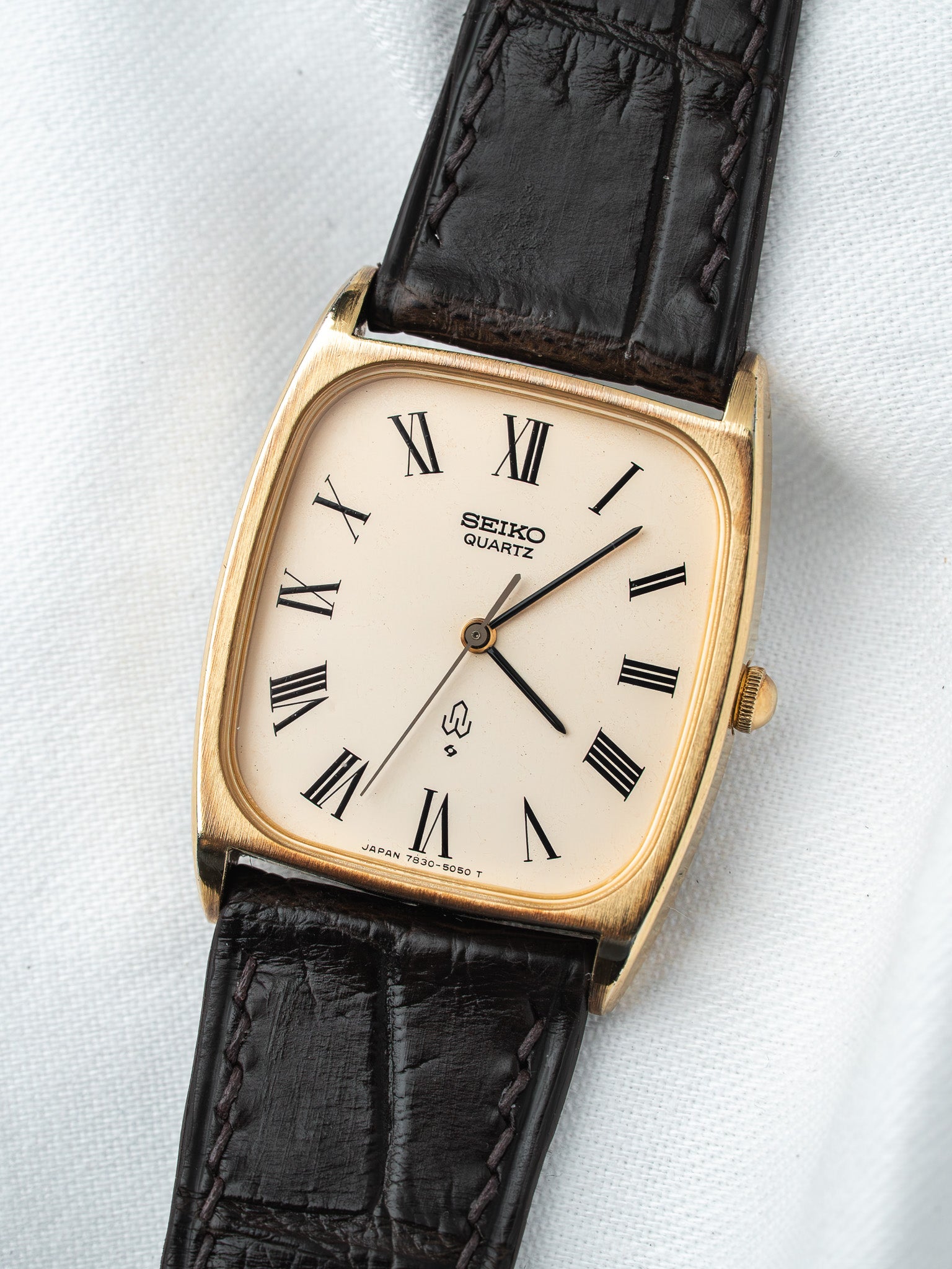 Seiko Quartz vintage watch with gold case, cream dial, Roman numerals, black leather strap
