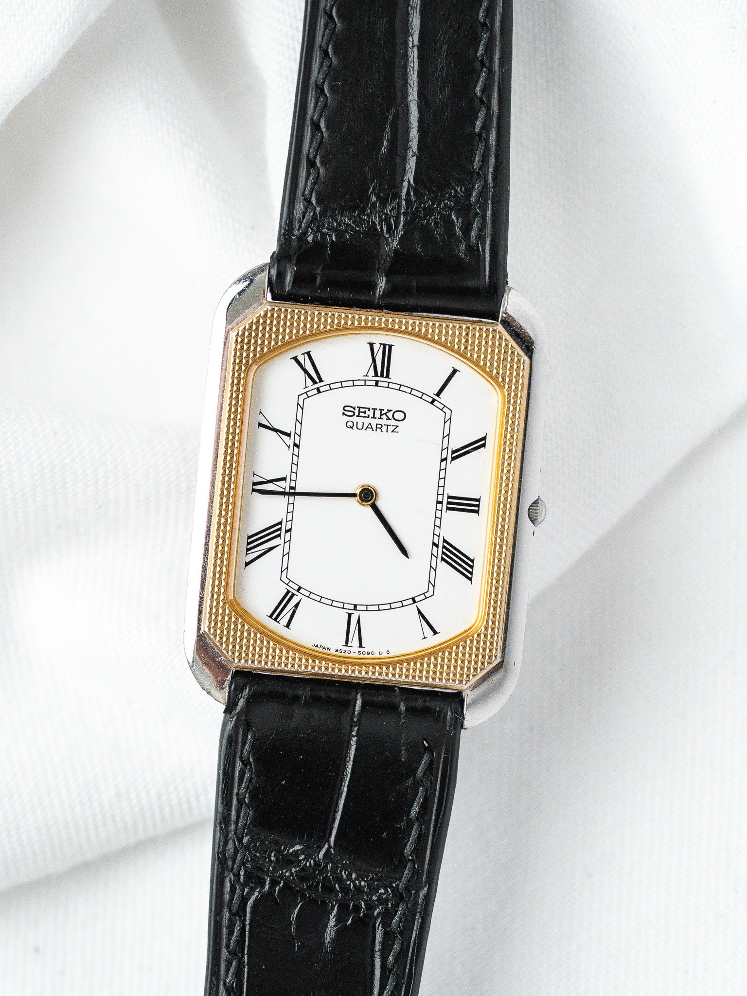 Seiko Quartz vintage watch with gold bezel, white dial, Roman numerals, black leather strap