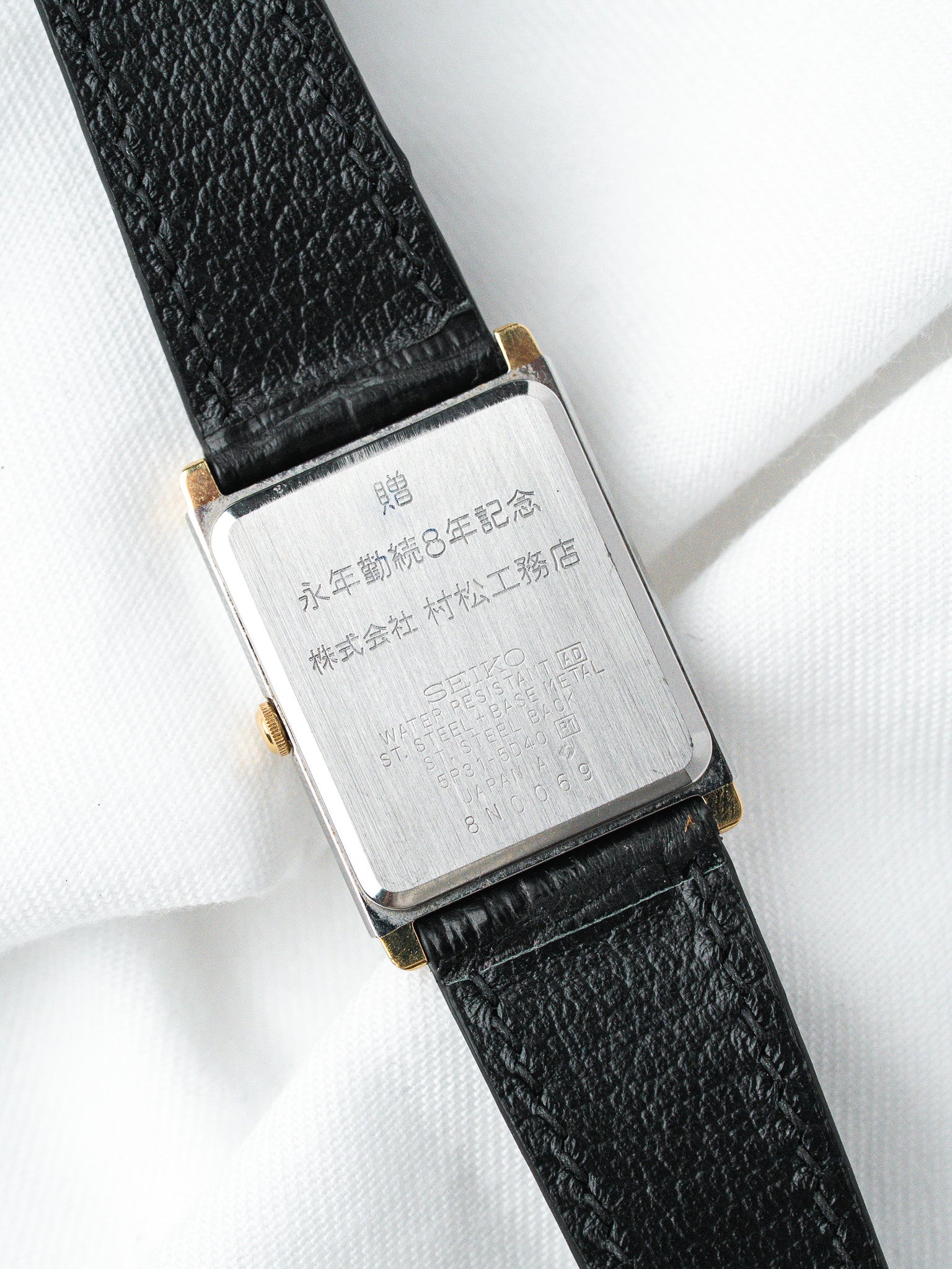 Seiko vintage watch with engraved case back, black leather strap, gold accents