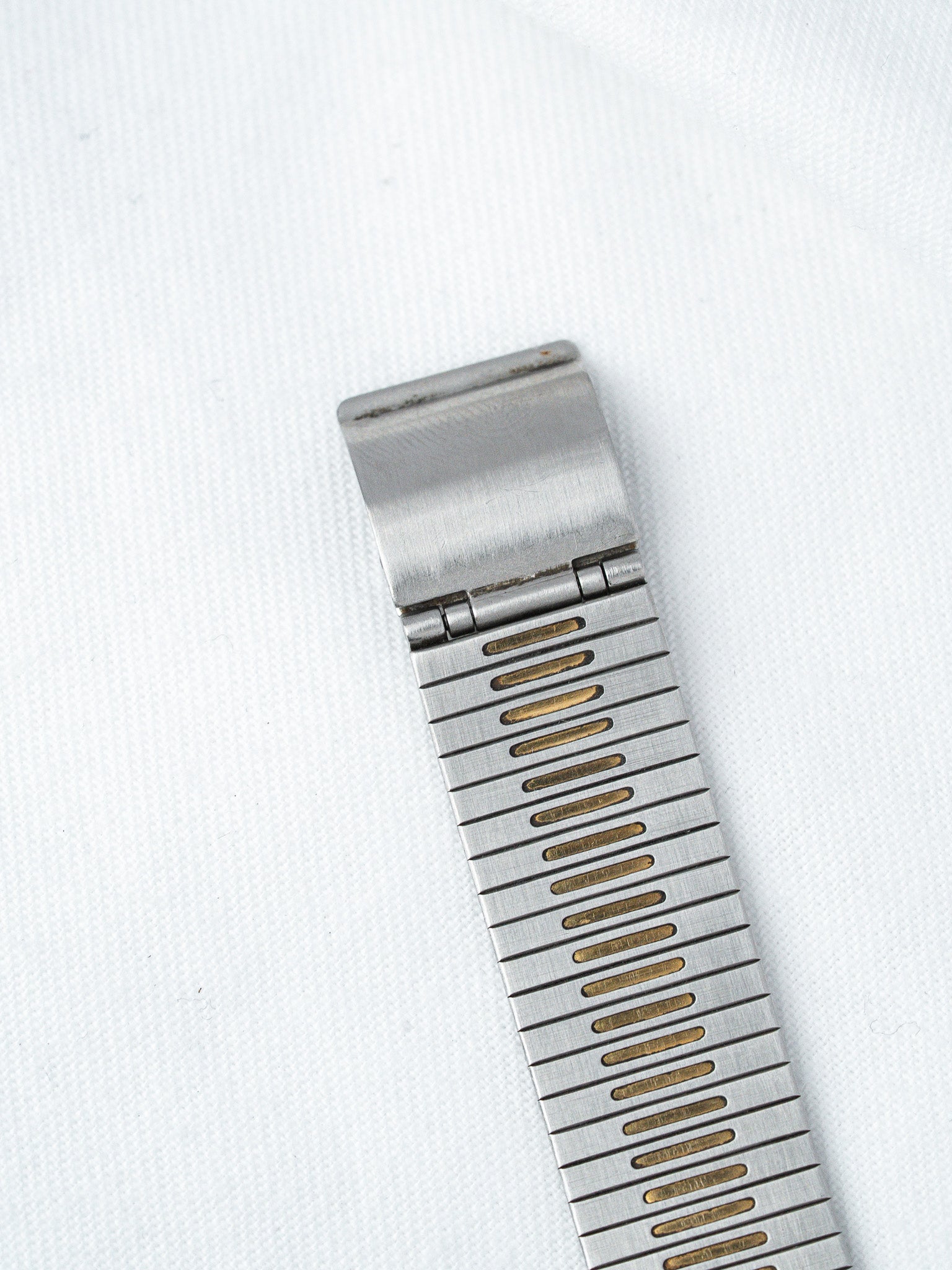Vintage Omega bracelet in stainless steel with gold accents on white background