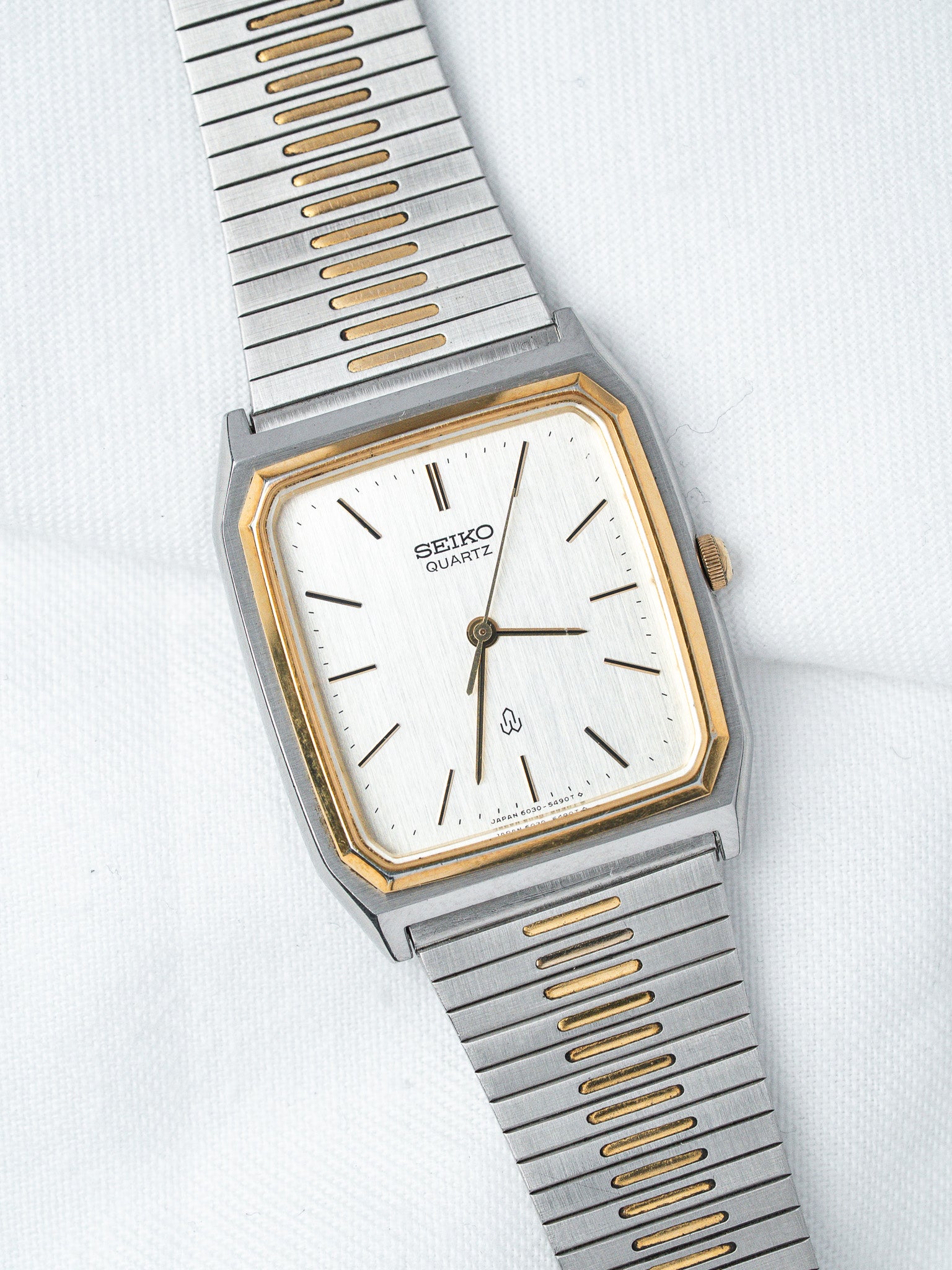 Seiko Quartz vintage watch with white dial, gold accents, and two-tone steel bracelet