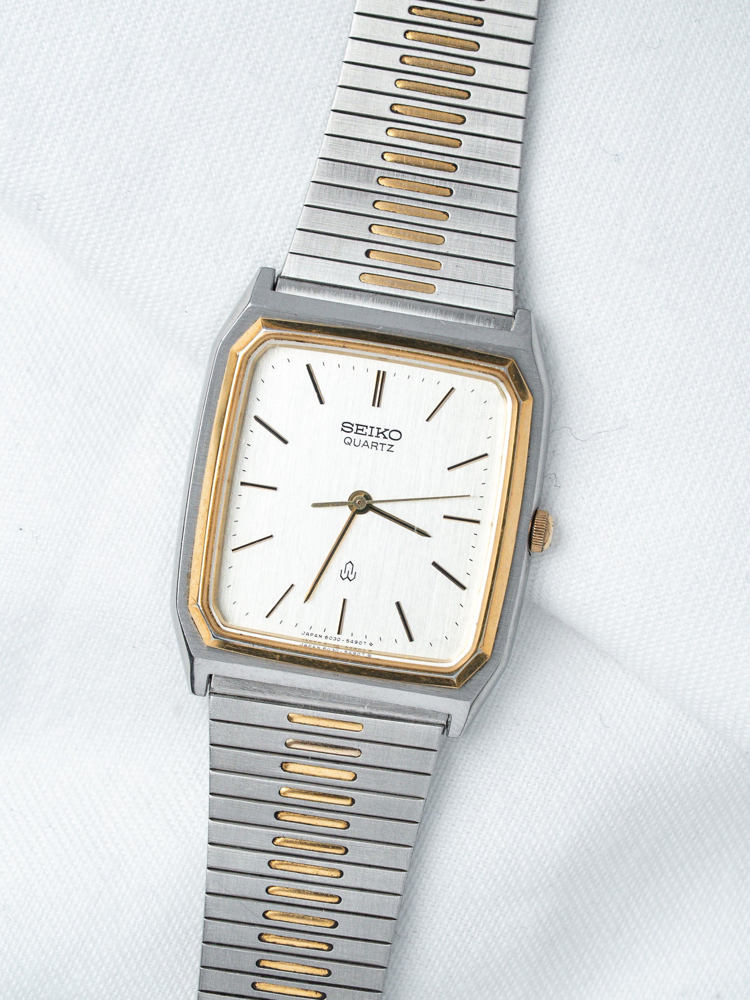 Seiko Quartz vintage watch with white dial, gold accents, and two-tone metal bracelet