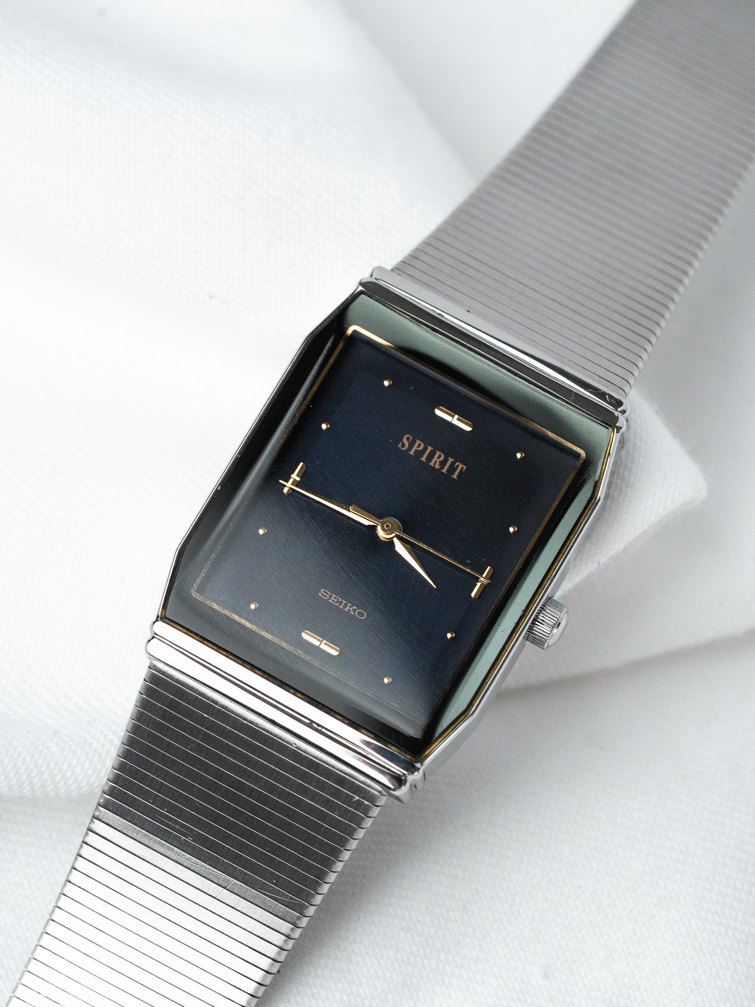 Seiko Spirit vintage watch with dark blue dial, gold markers, and steel mesh bracelet