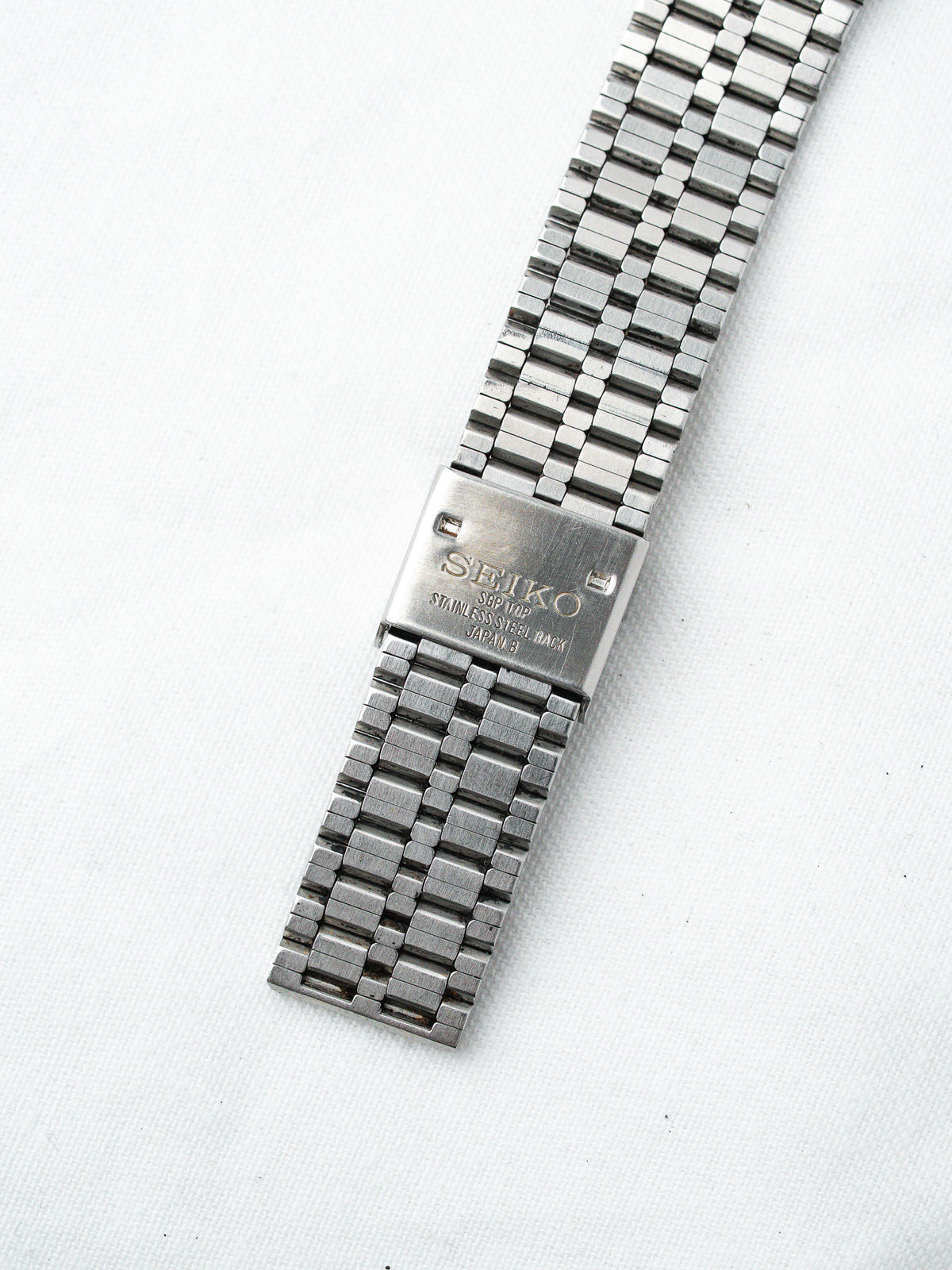 Seiko vintage stainless steel watch back with engraved logo on white background