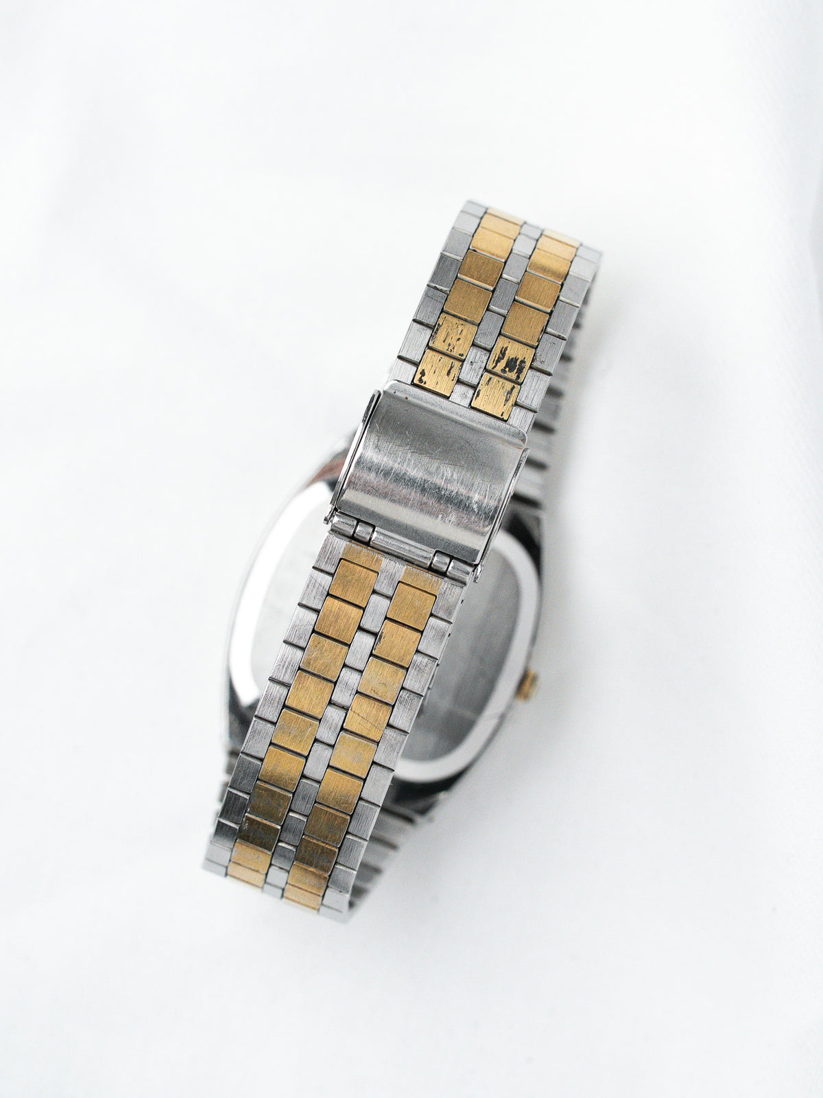 Vintage two-tone stainless steel and gold watch bracelet on white background