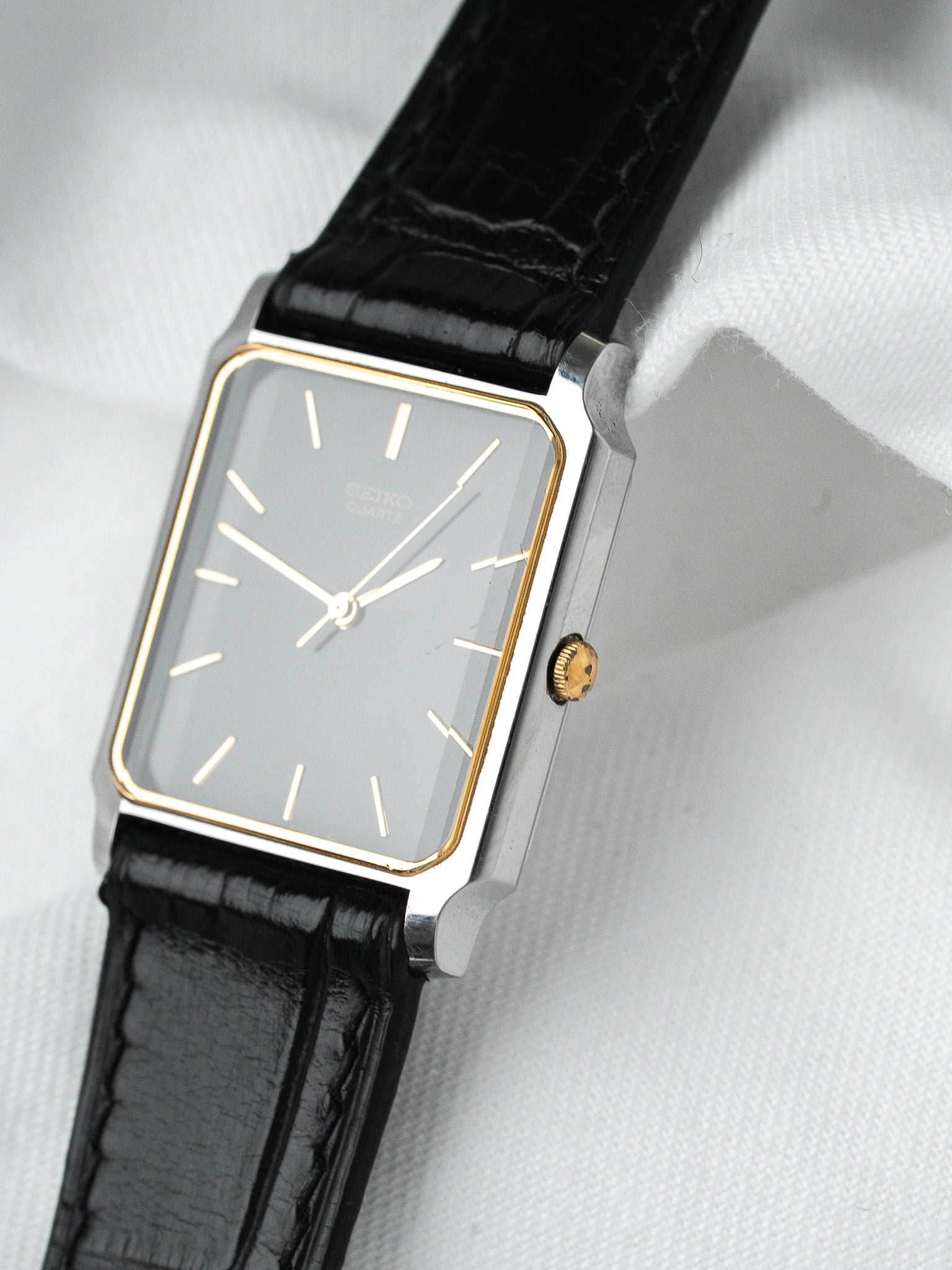 Seiko vintage watch with rectangular case, grey dial, gold accents, black leather strap