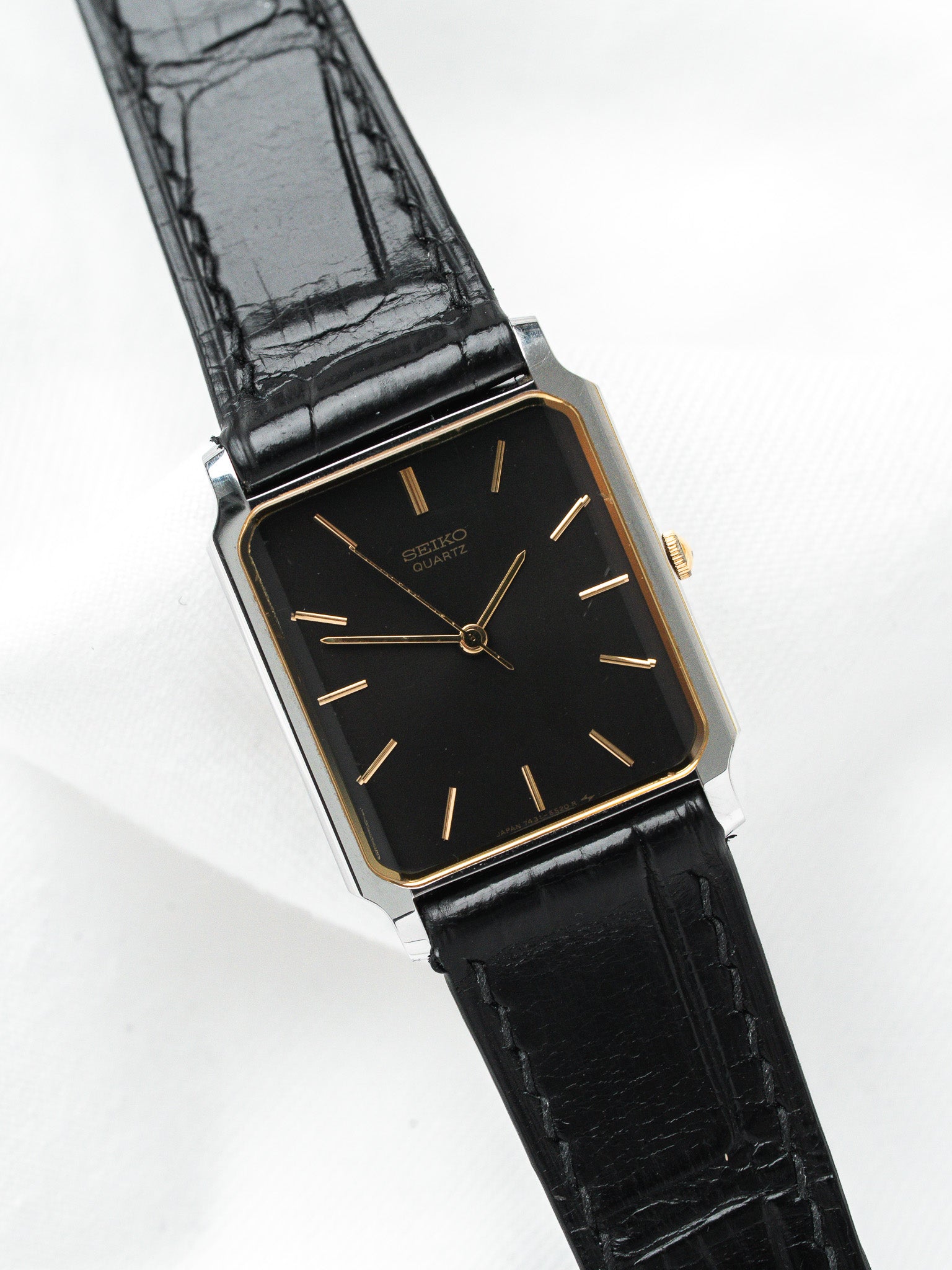 Seiko Quartz vintage watch with black dial, gold markers, and black leather strap