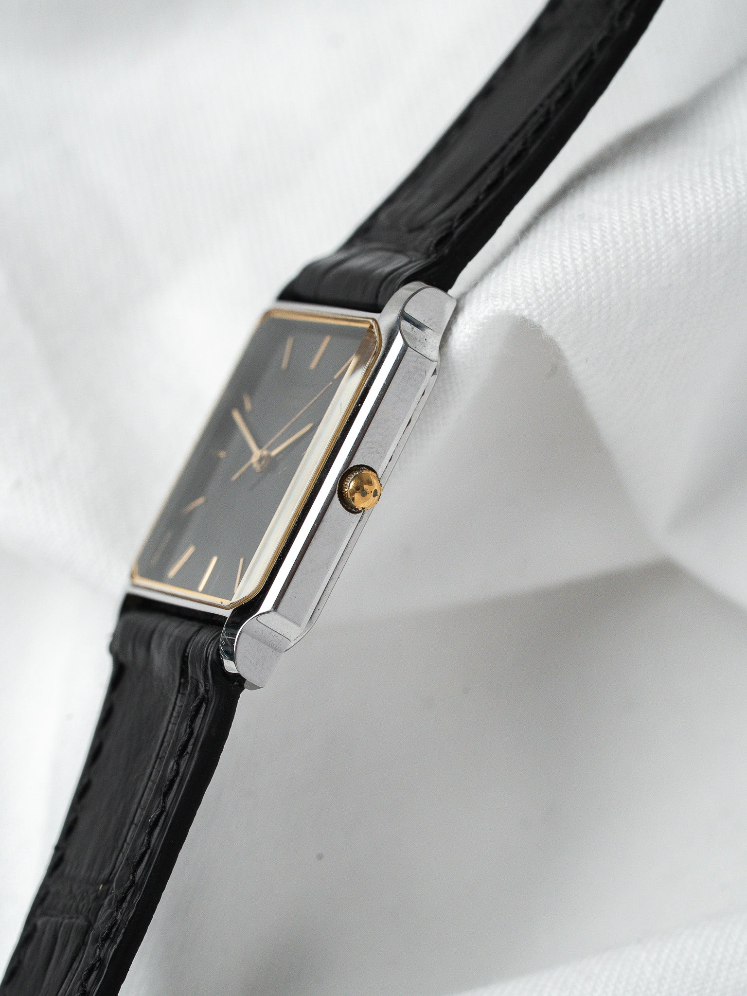 Cartier Tank vintage watch with black dial, gold accents, and black leather strap