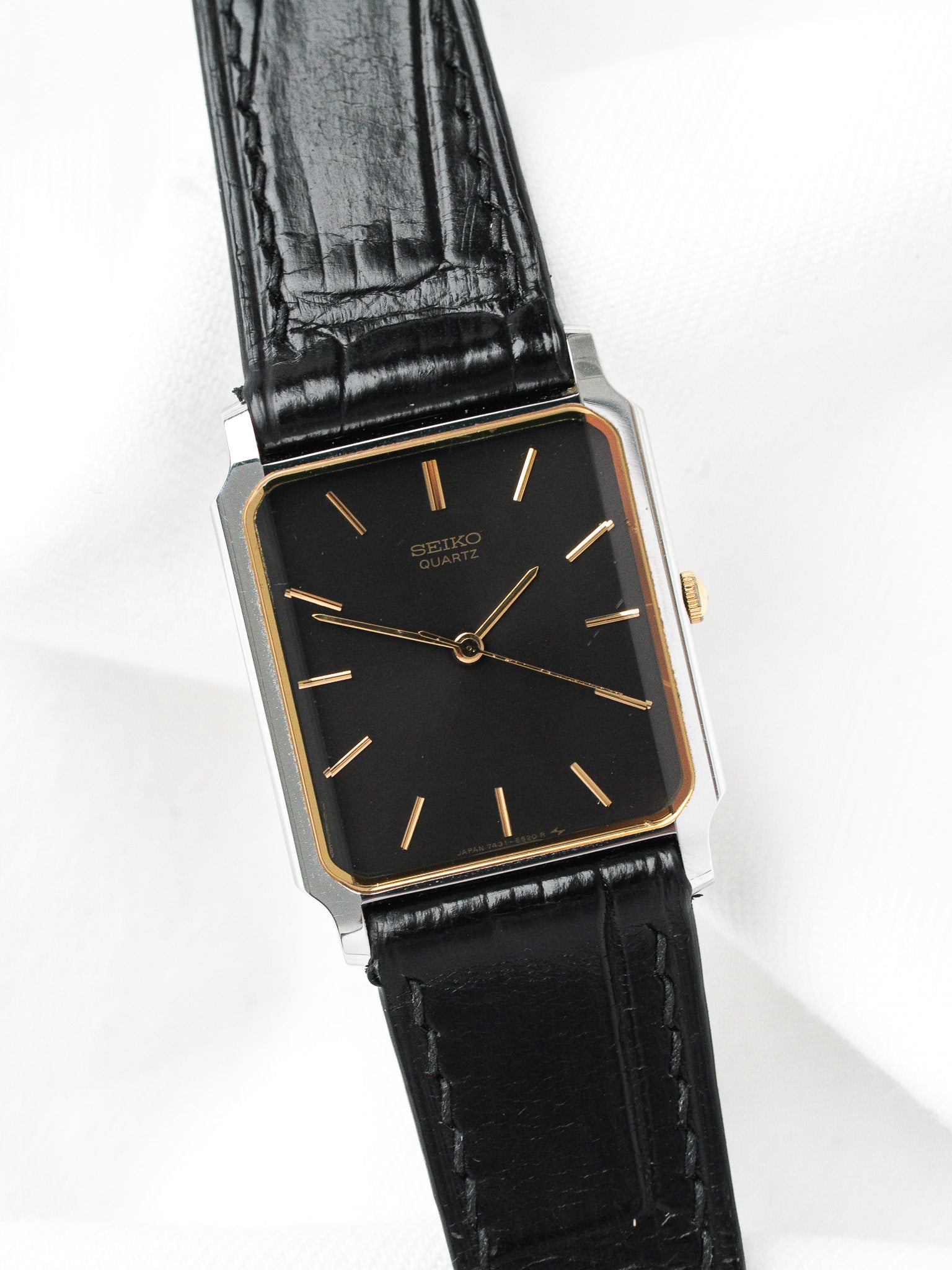 Seiko Quartz vintage watch with black dial, gold markers, and black leather strap