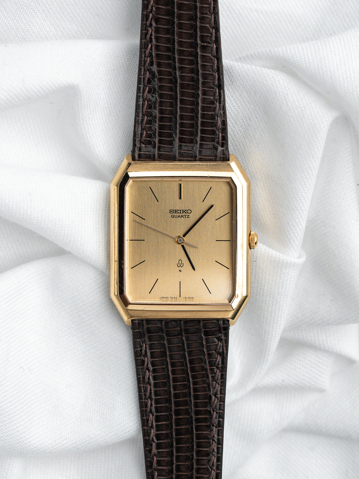 Montre Seiko Quartz vintage, boîtier rectangulaire doré, cadran champagne et bracelet cuir marron