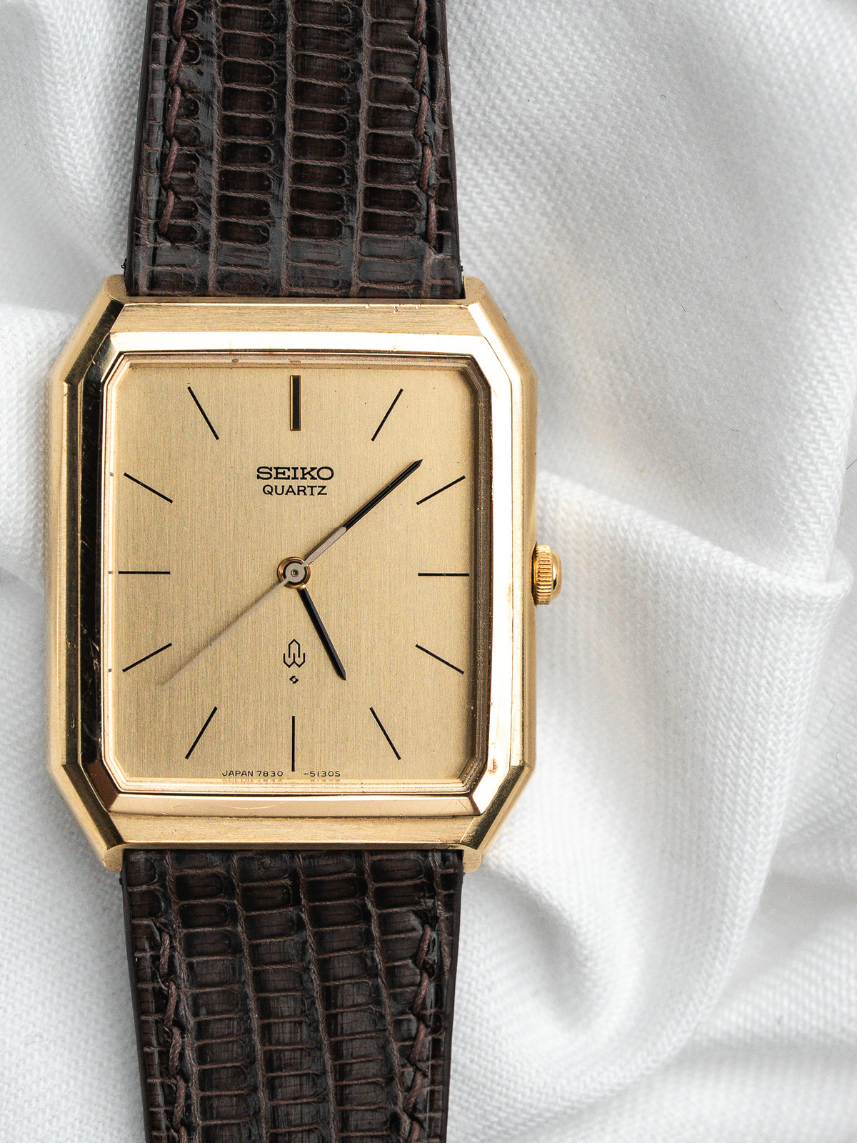 Montre Seiko Quartz vintage, boîtier rectangulaire doré, cadran champagne et bracelet cuir marron