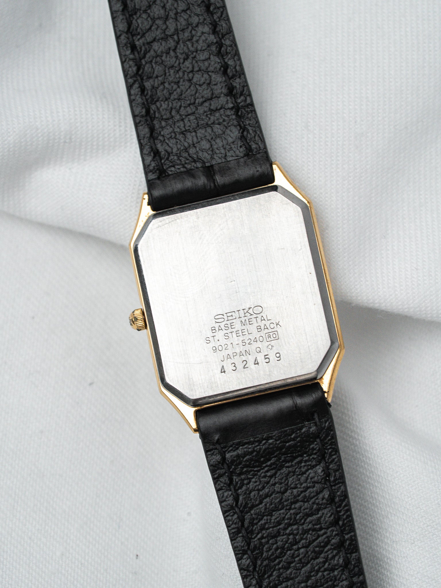 Seiko vintage watch with gold-tone case, black leather strap, steel back engraved
