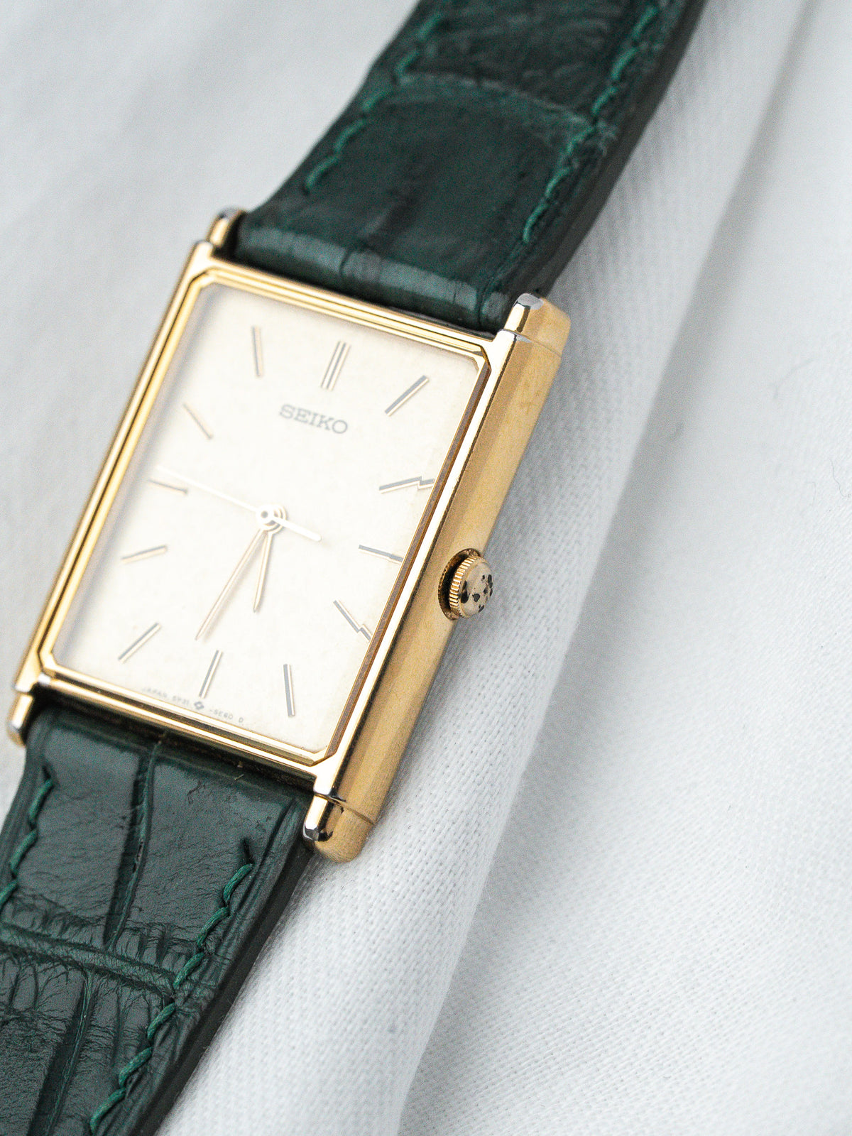 Seiko vintage watch with gold case, white dial, green leather strap