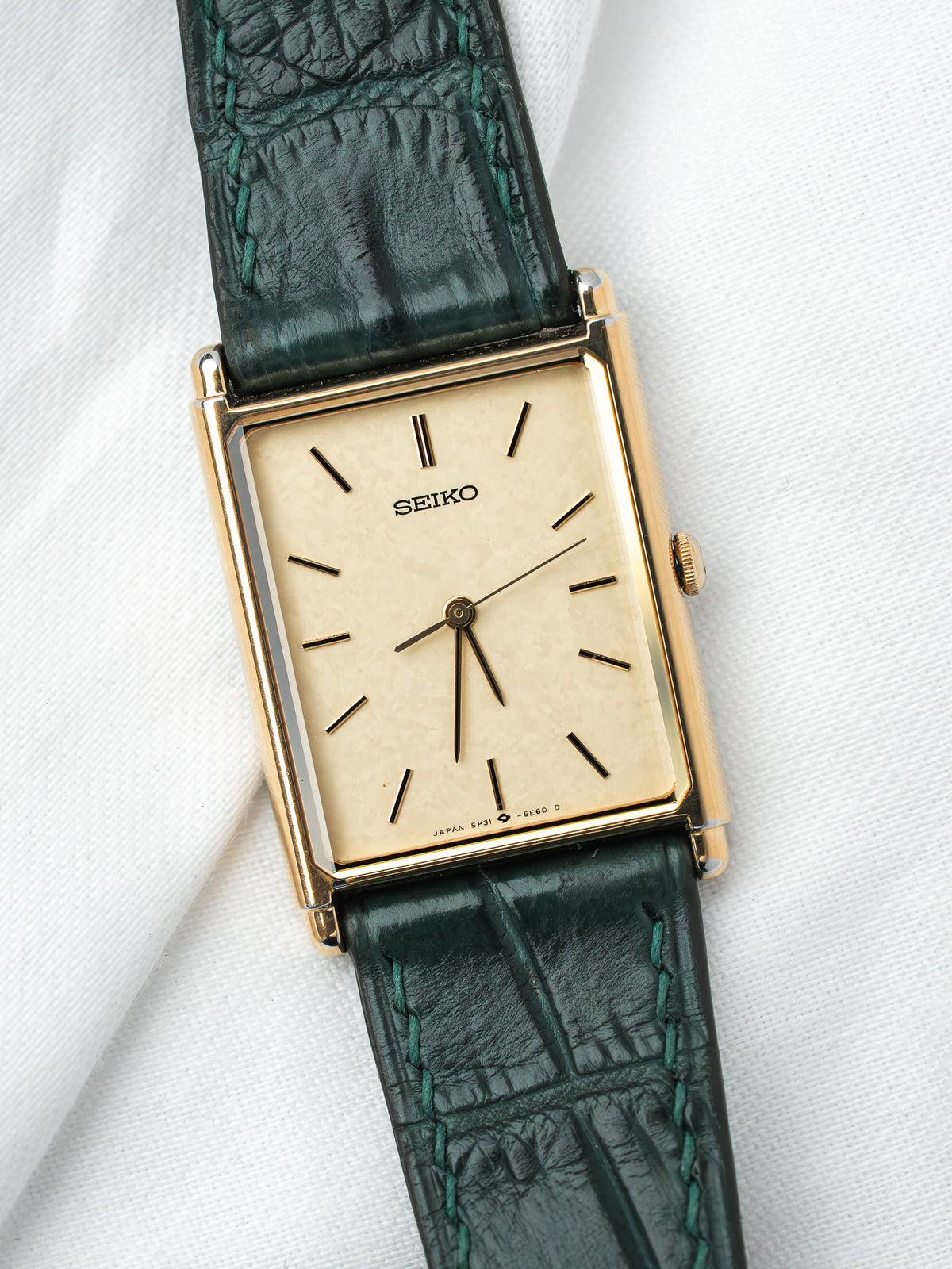 Seiko vintage watch with gold case, cream dial, and green alligator strap