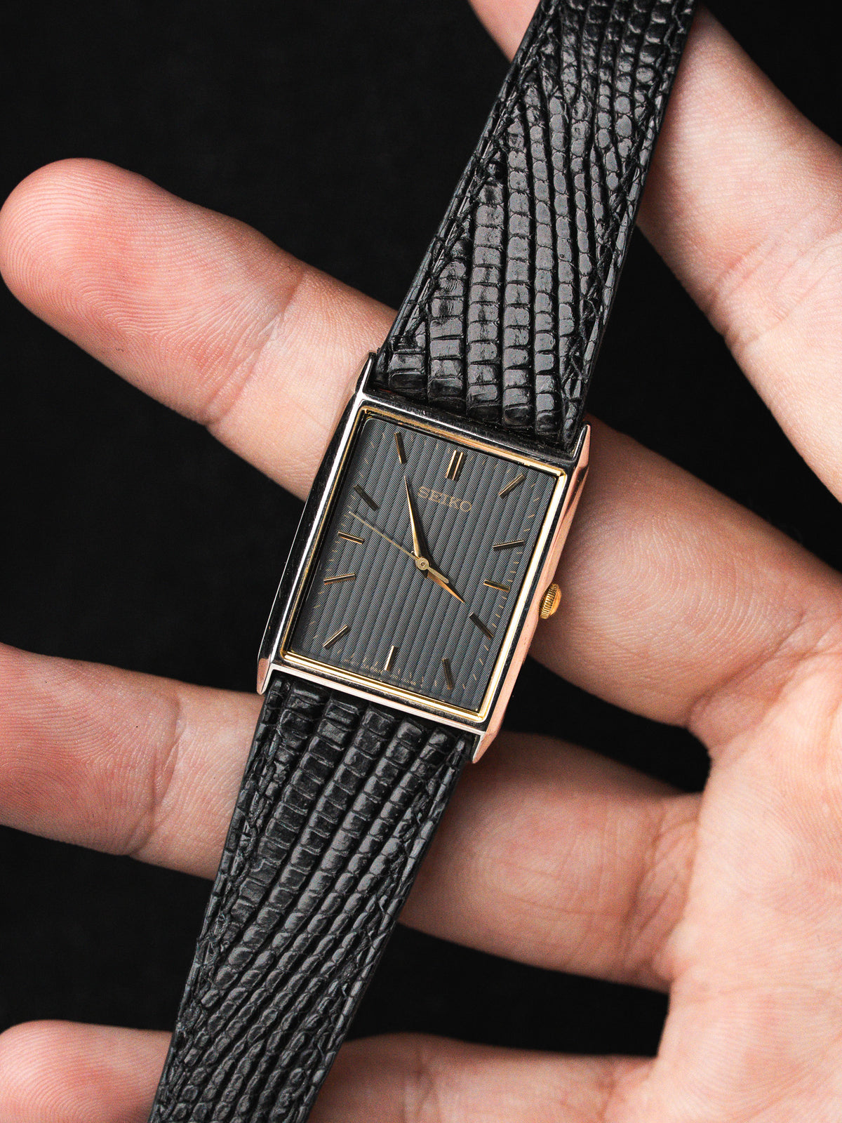 Tenue en main sur fond noir - Montre Seiko Tank Vintage V701-5E20 - Atelier Victor