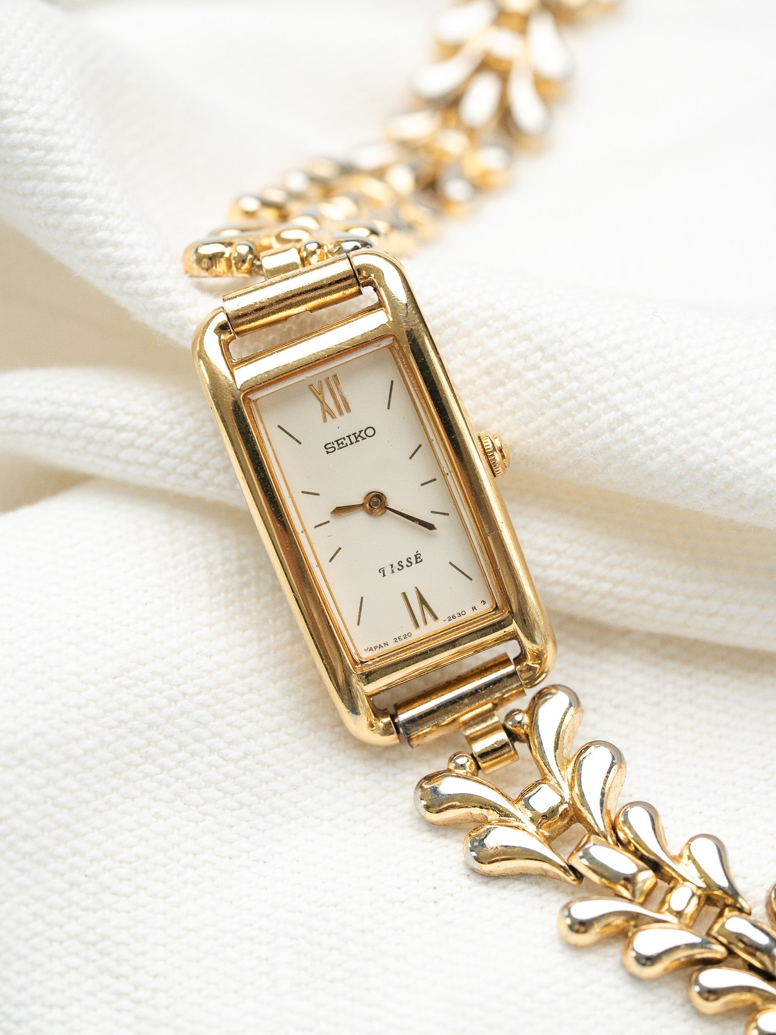 Seiko Tissé vintage watch with gold rectangular case and white dial on fabric