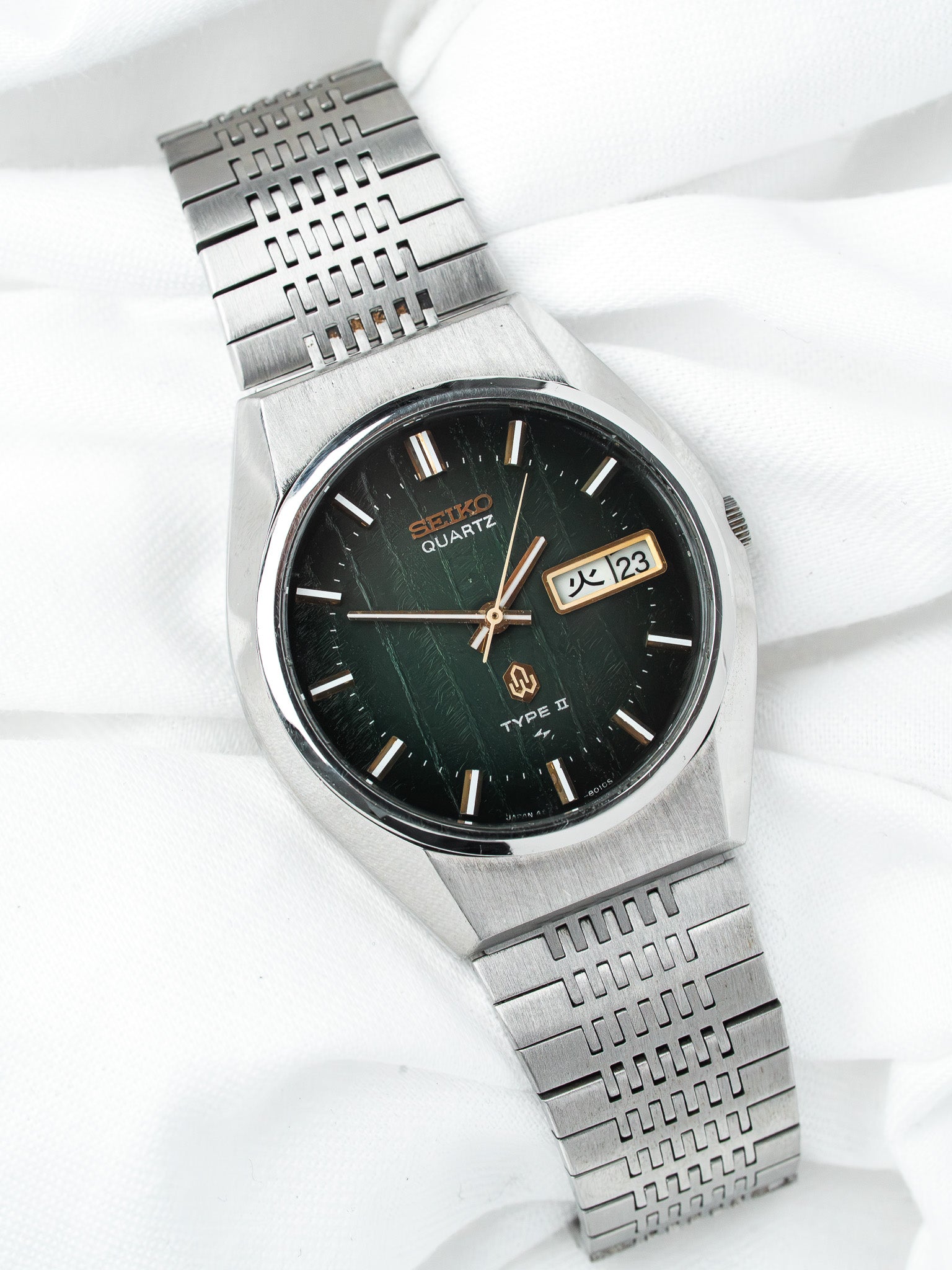 Seiko Quartz Type II vintage watch with green textured dial and steel bracelet on white fabric
