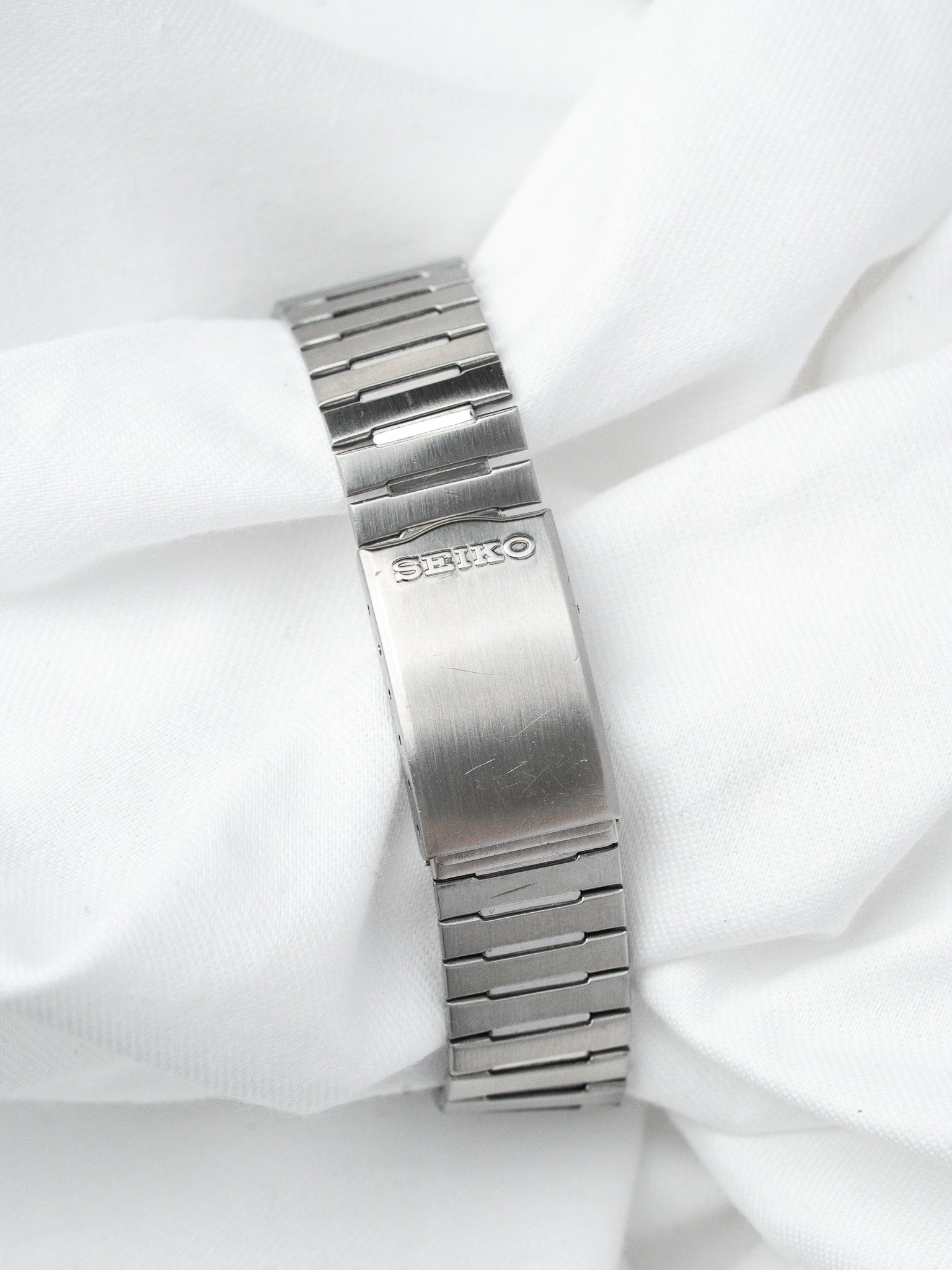 Seiko vintage watch bracelet in brushed stainless steel on white fabric